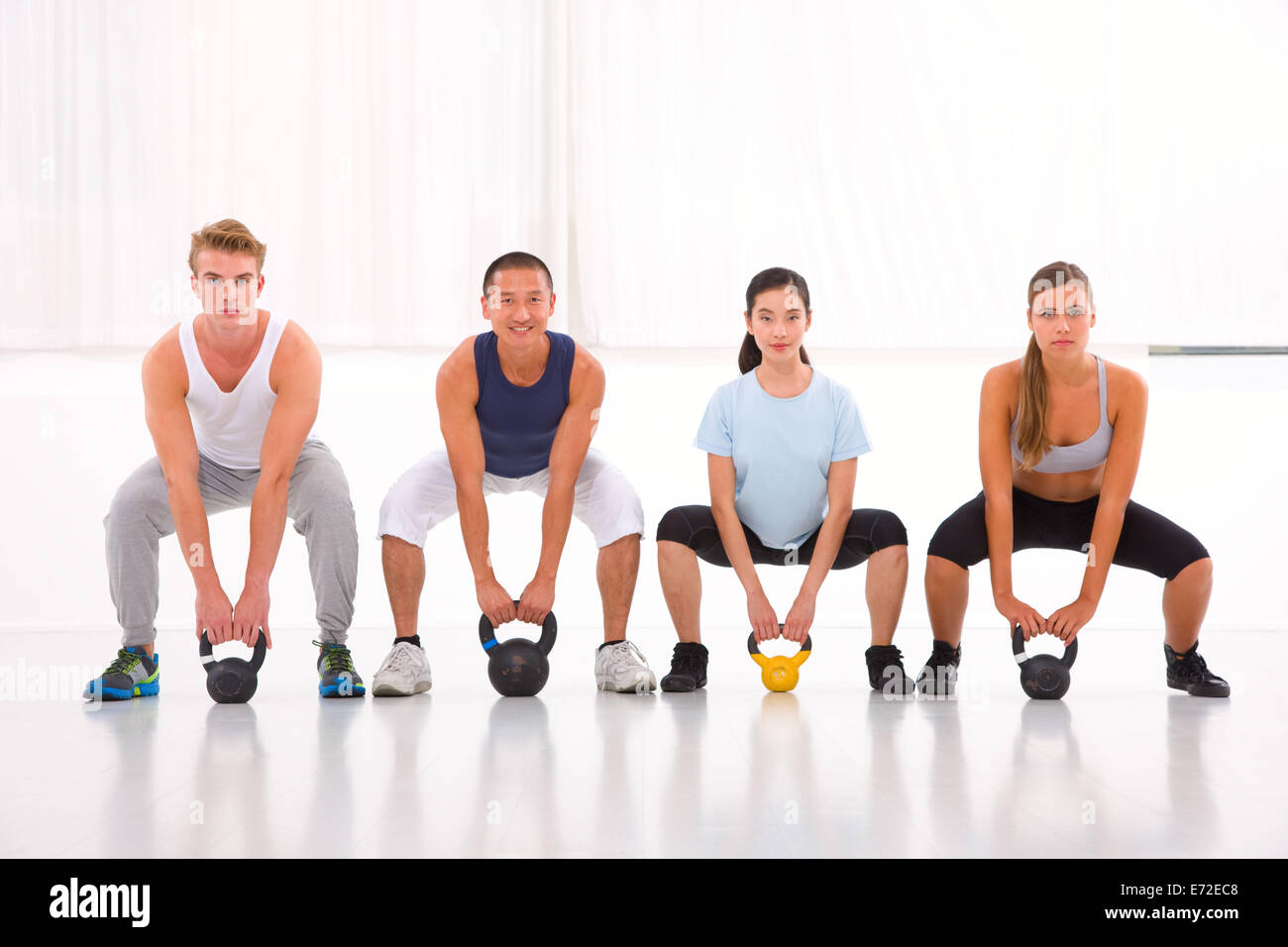 Multiethnic group of people doing kettlebell crossfit exercise Stock Photo