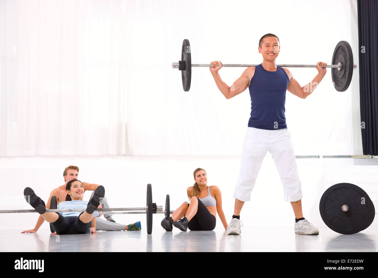 Tough young woman exercising with barbell. Determined female athlete  lifting heavy weights Stock Photo - Alamy