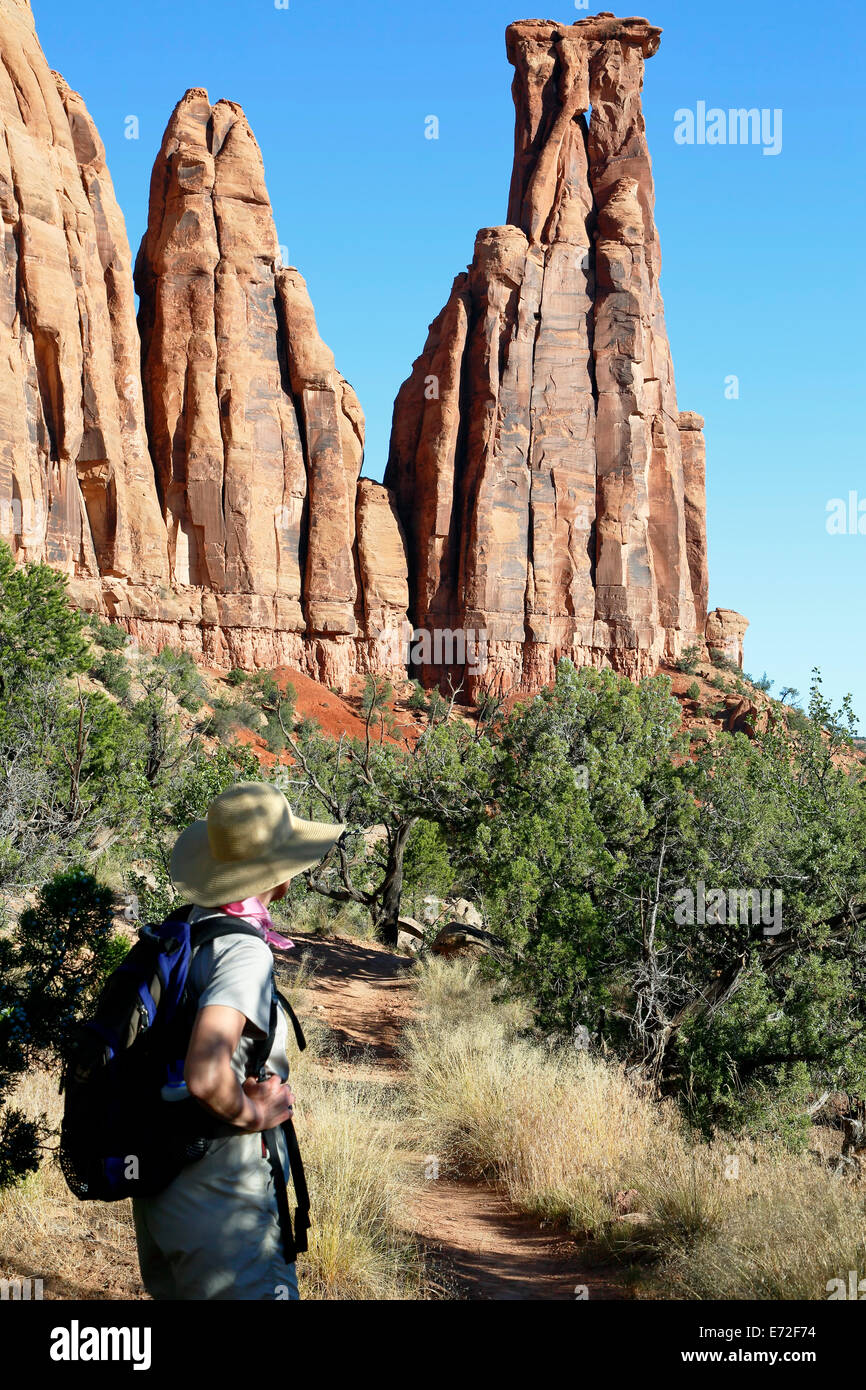 Female hiker below Kissing Couple sandstone monument, Canyon Monuments Trail, Colorado National Monument, Grand Junction USA Stock Photo