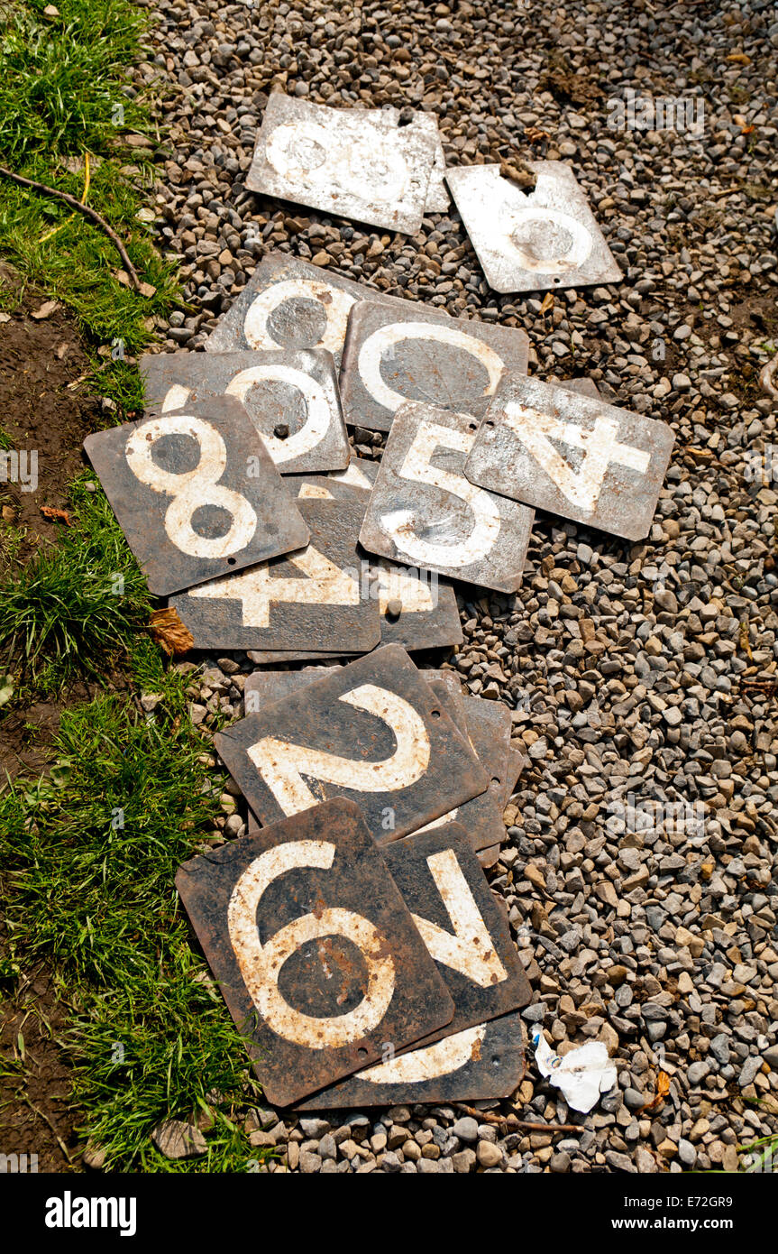 'Hang On' number plates used for cricket scoreboard lying on a gravel path Stock Photo