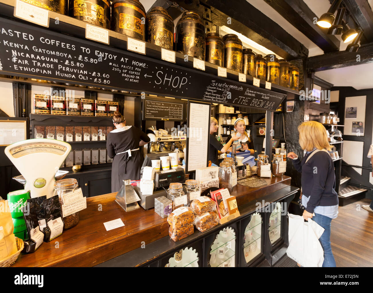 A woman buying tea at the counter, Stokes High Bridge cafe interior, Lincoln city, Lincolnshire UK Stock Photo