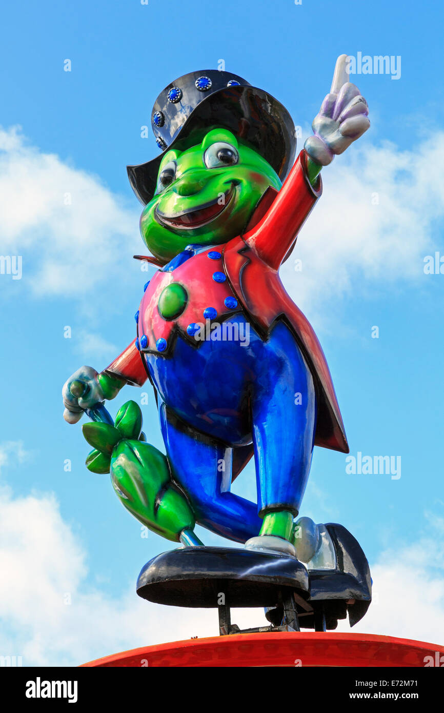 Green frog in top hat and tails on top of a fairground ride. Stock Photo
