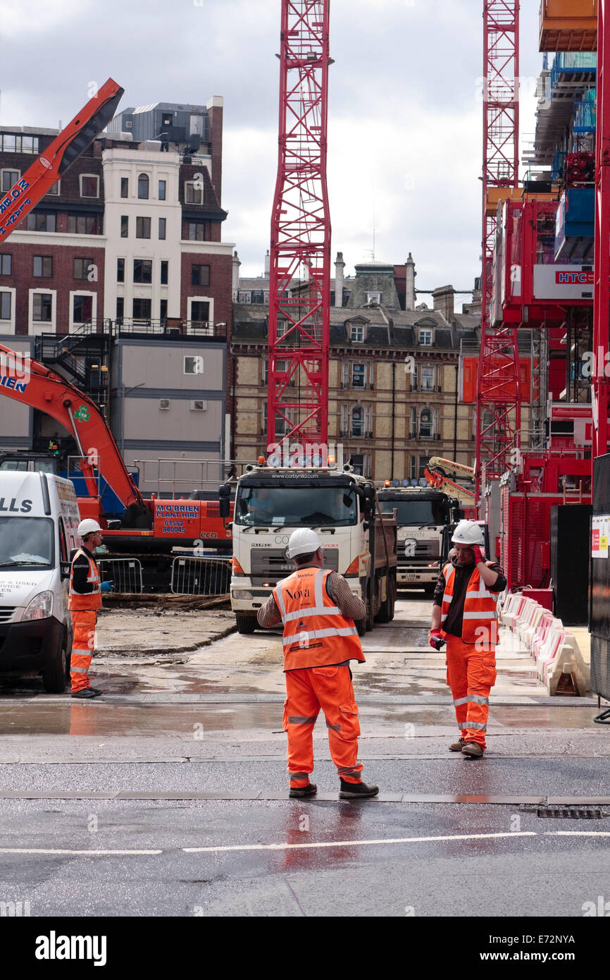 Traffic marshalls, in hi-viz clothing, on an industrial building site directing lorries in and out of the site Stock Photo