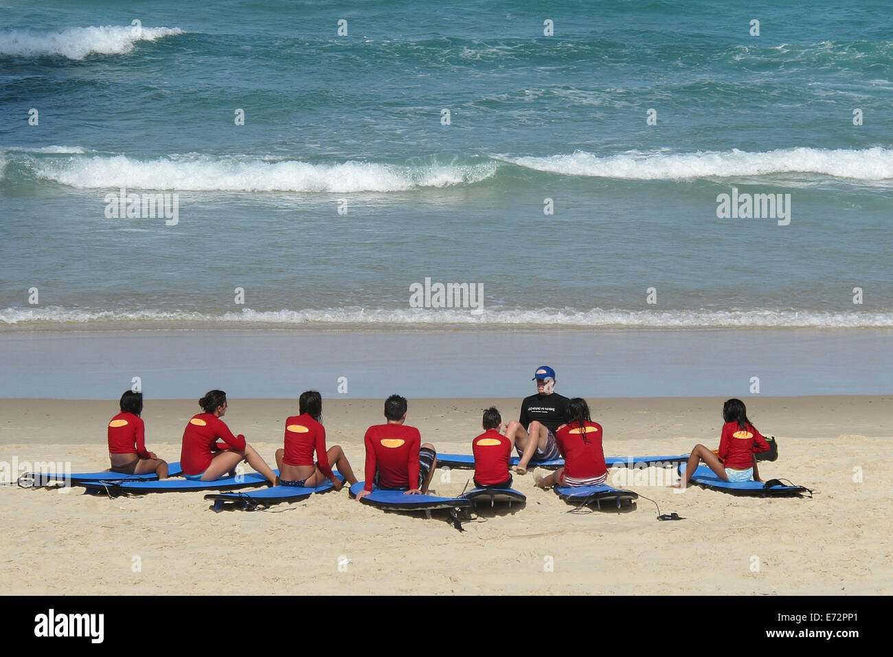 Teenagers having a surf board riding lesson on Surfer's Paradise beach on the Gold Coast in Australia Stock Photo