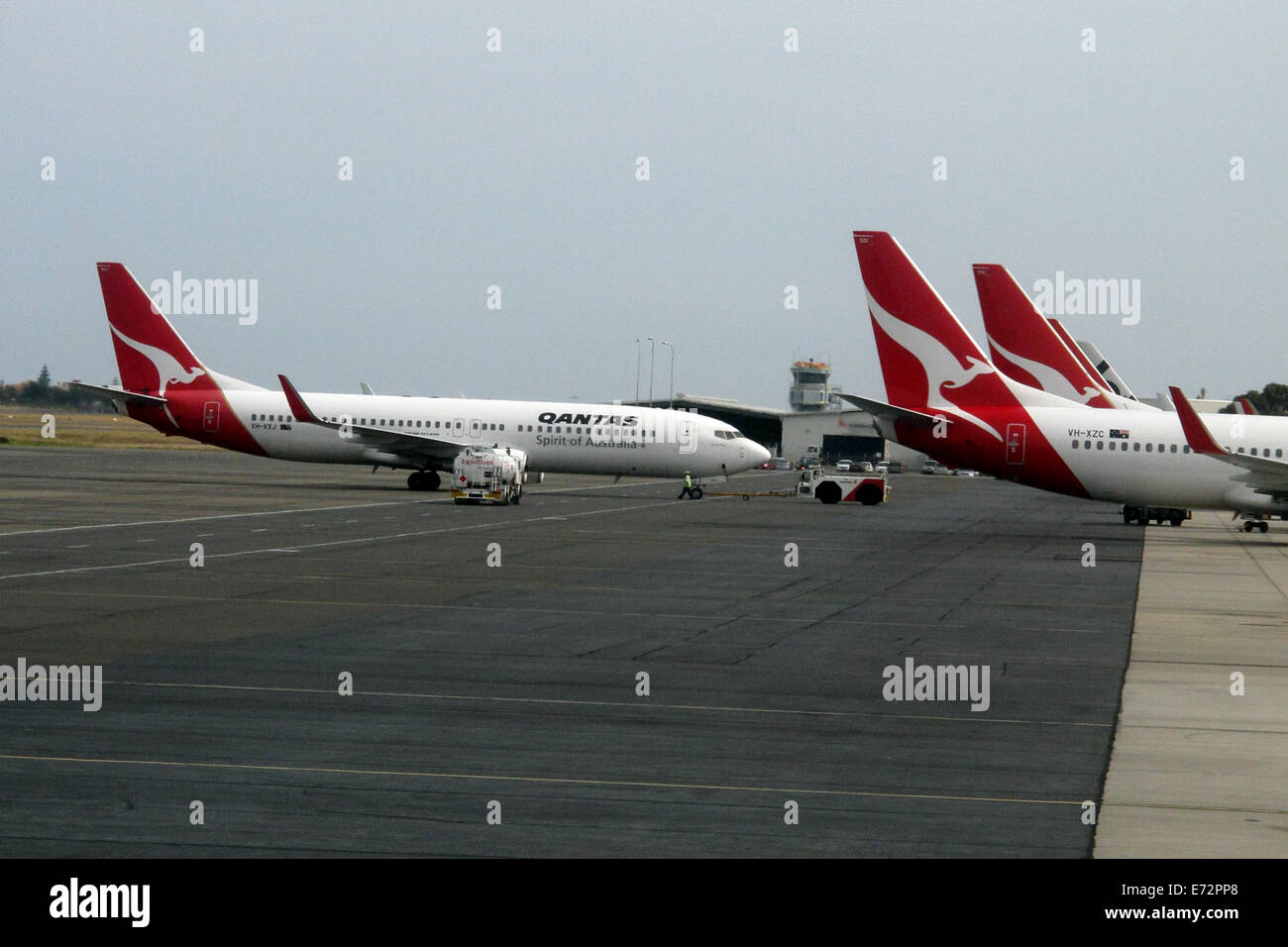 Qantas plane being pushed back ready for take off while other planes wait to take on passengers. Adelaide Airport Australia. Stock Photo