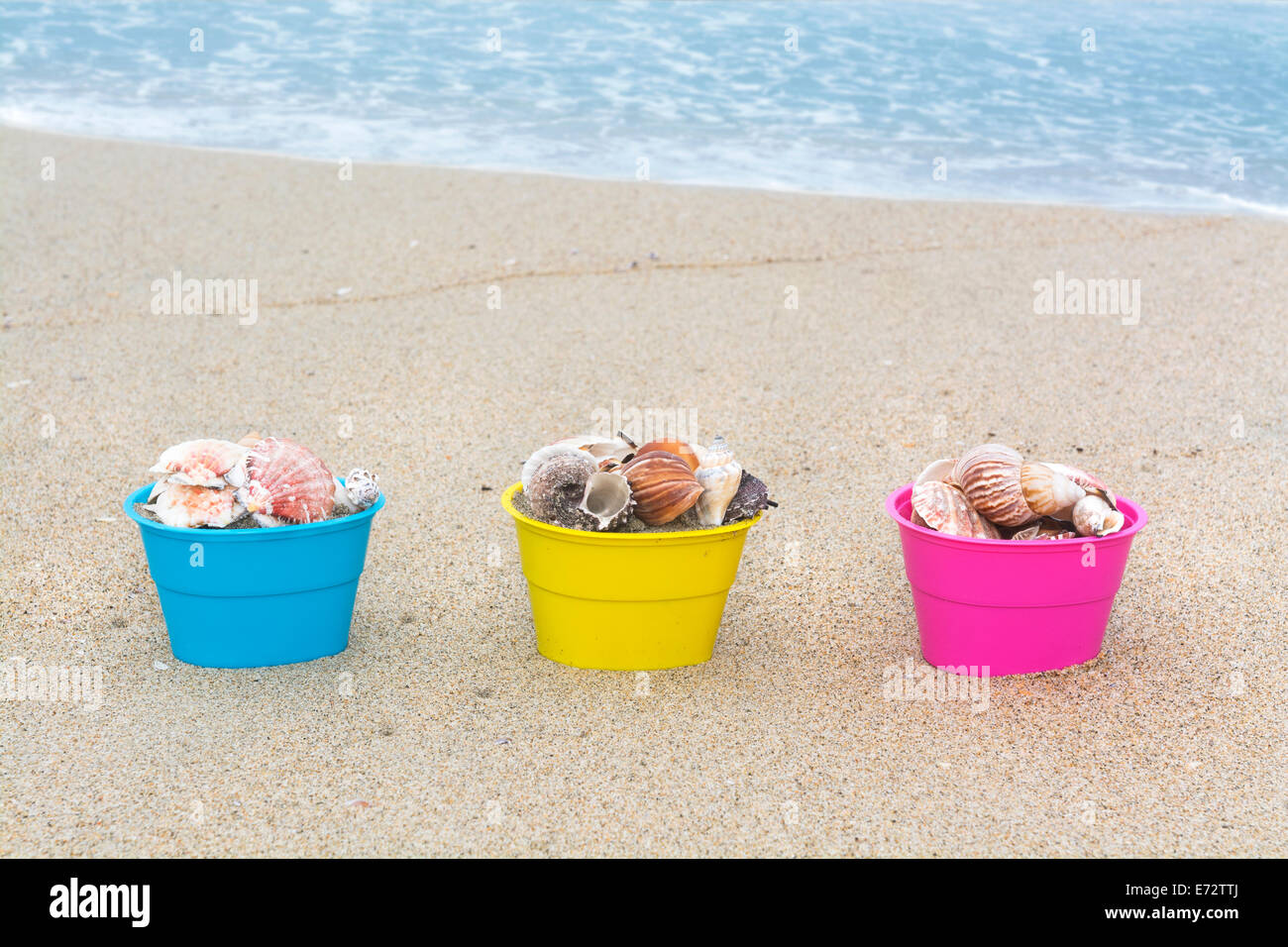 Decorative Easter egg baskets on the beach along the waters edge filled with seashells for use as a background. Stock Photo