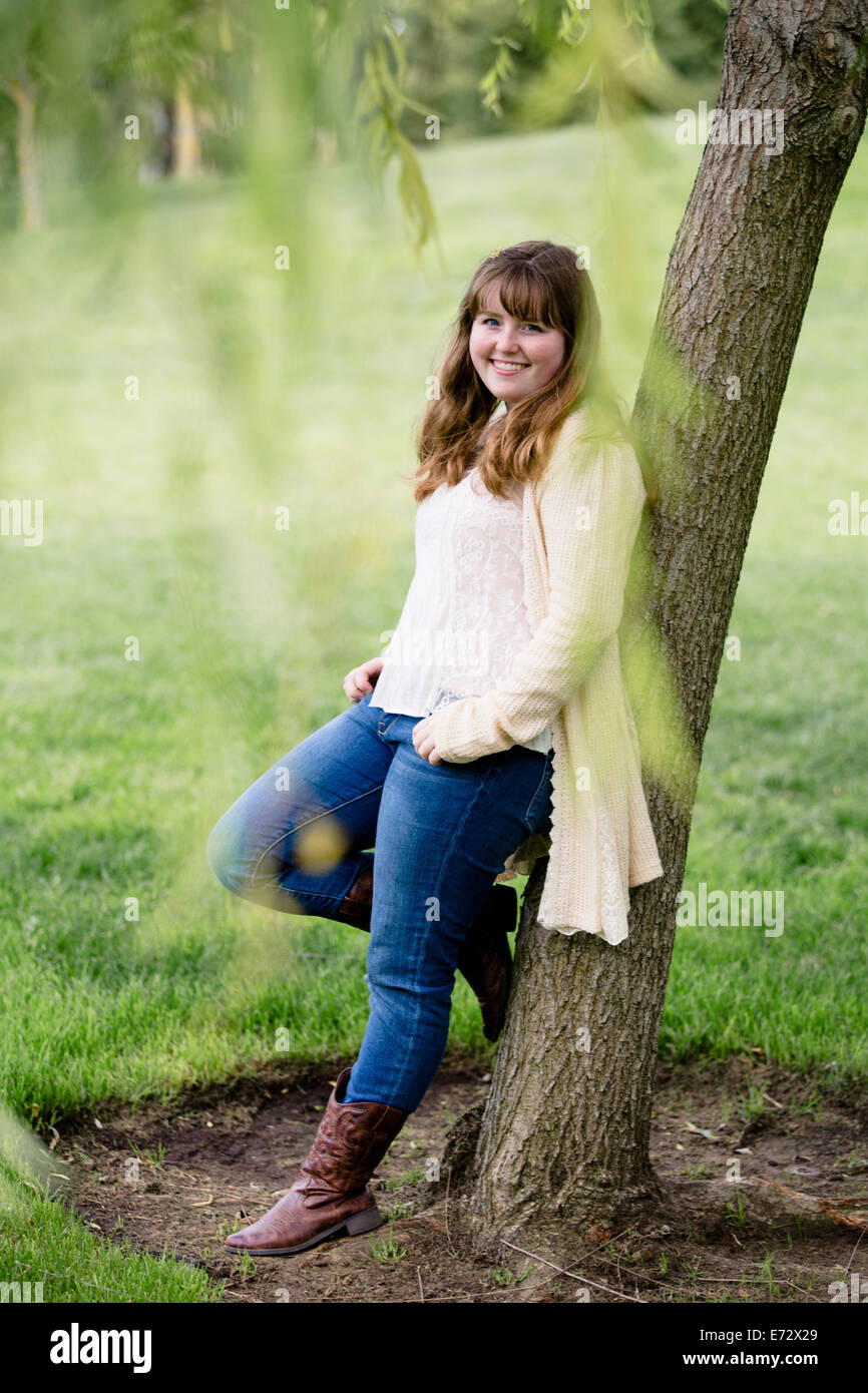 Portrait of teenage girl (13-15) leaning against tree Stock Photo