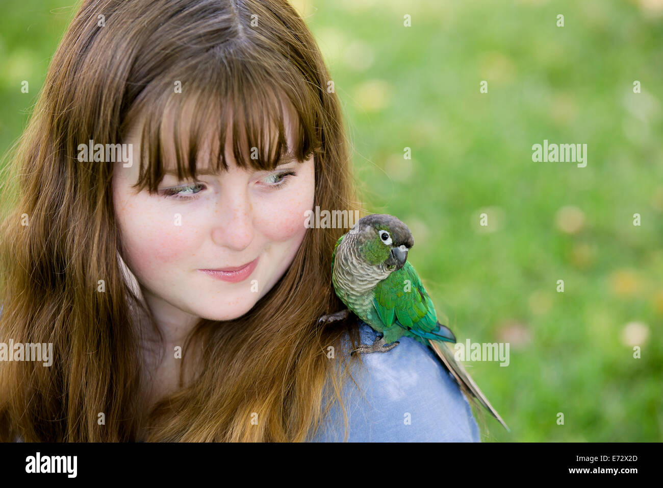 Teenage girl (13-15) with parrot Stock Photo