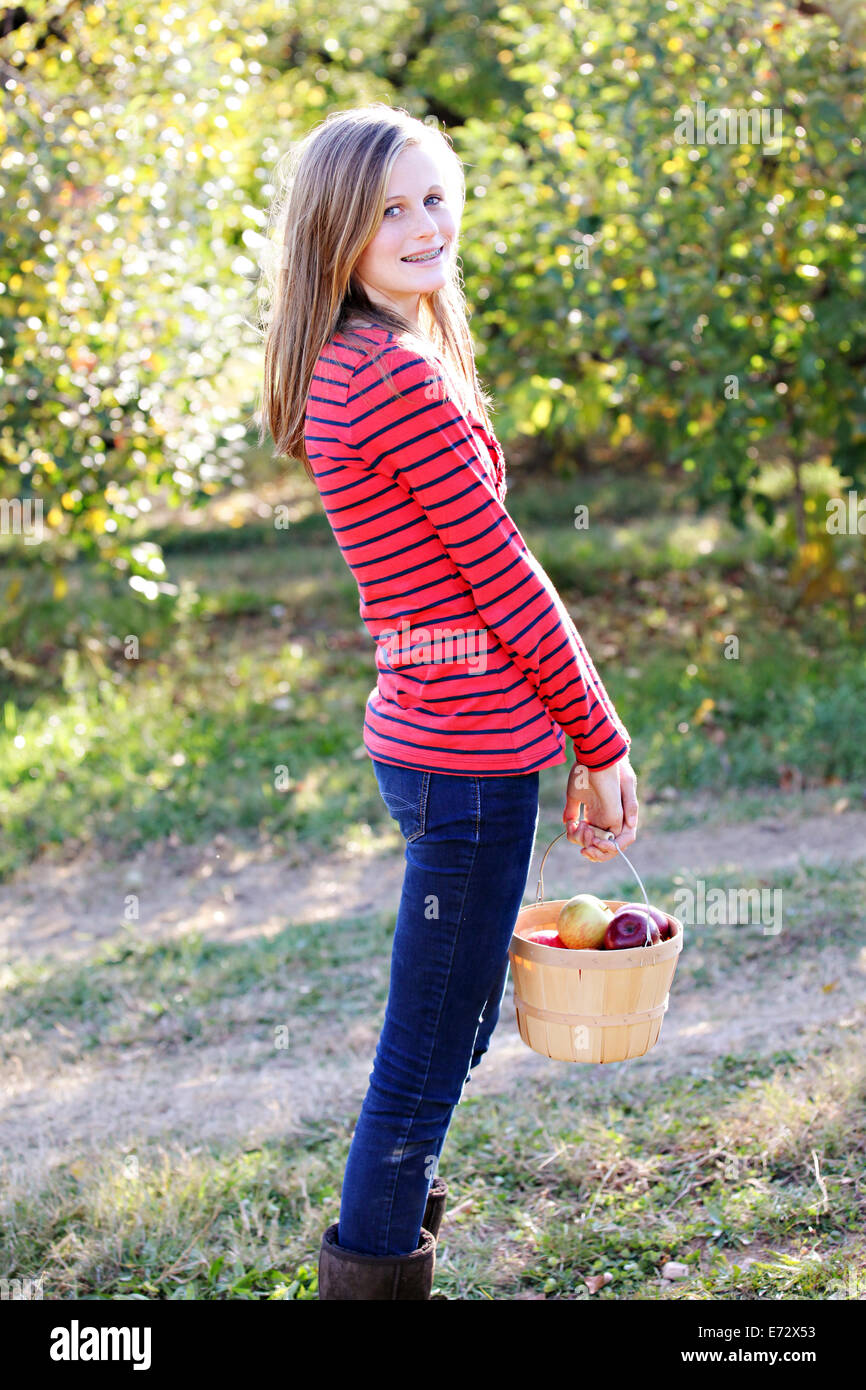 Portrait of girl (13-15) holding basket with apples Stock Photo