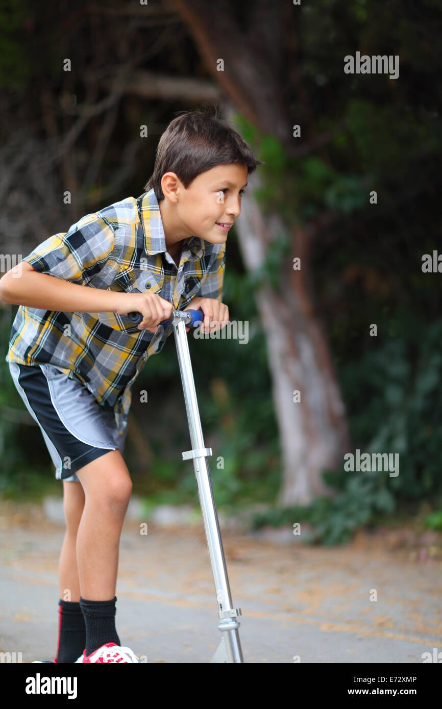Young boy playing on a scooter Stock Photo