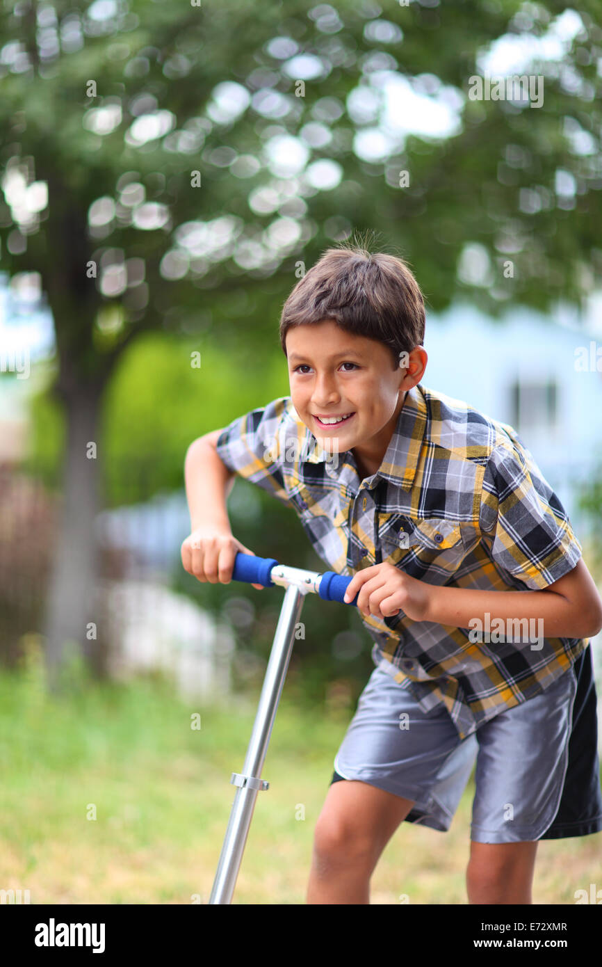 Young boy playing on a scooter Stock Photo