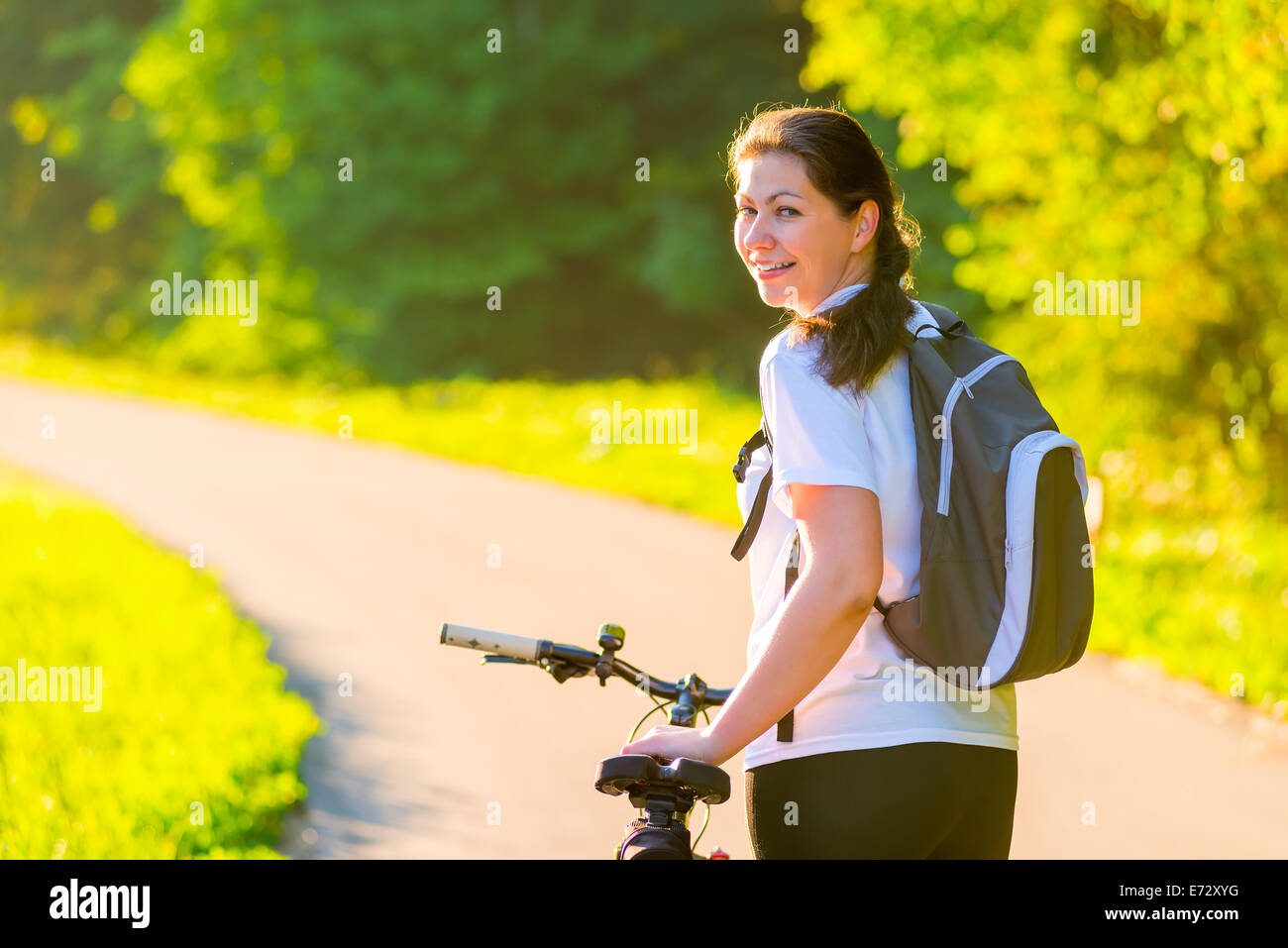 Brunette rides a bicycle on a sunny morning Stock Photo
