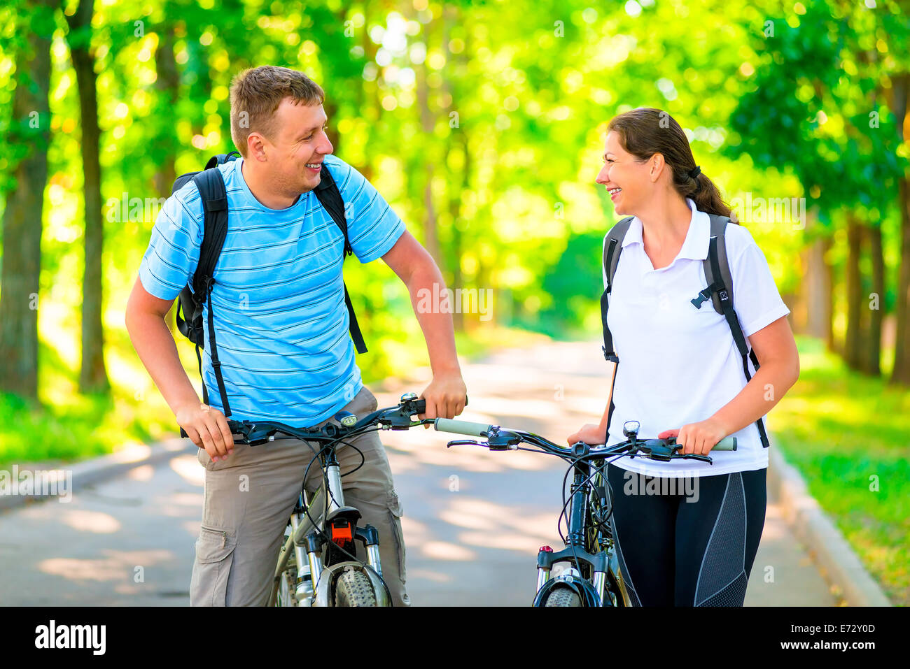 cheerful and happy cyclists in the morning park Stock Photo - Alamy