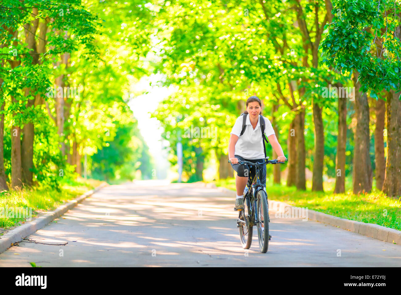 young girl on a bicycle in a park in the early morning Stock Photo