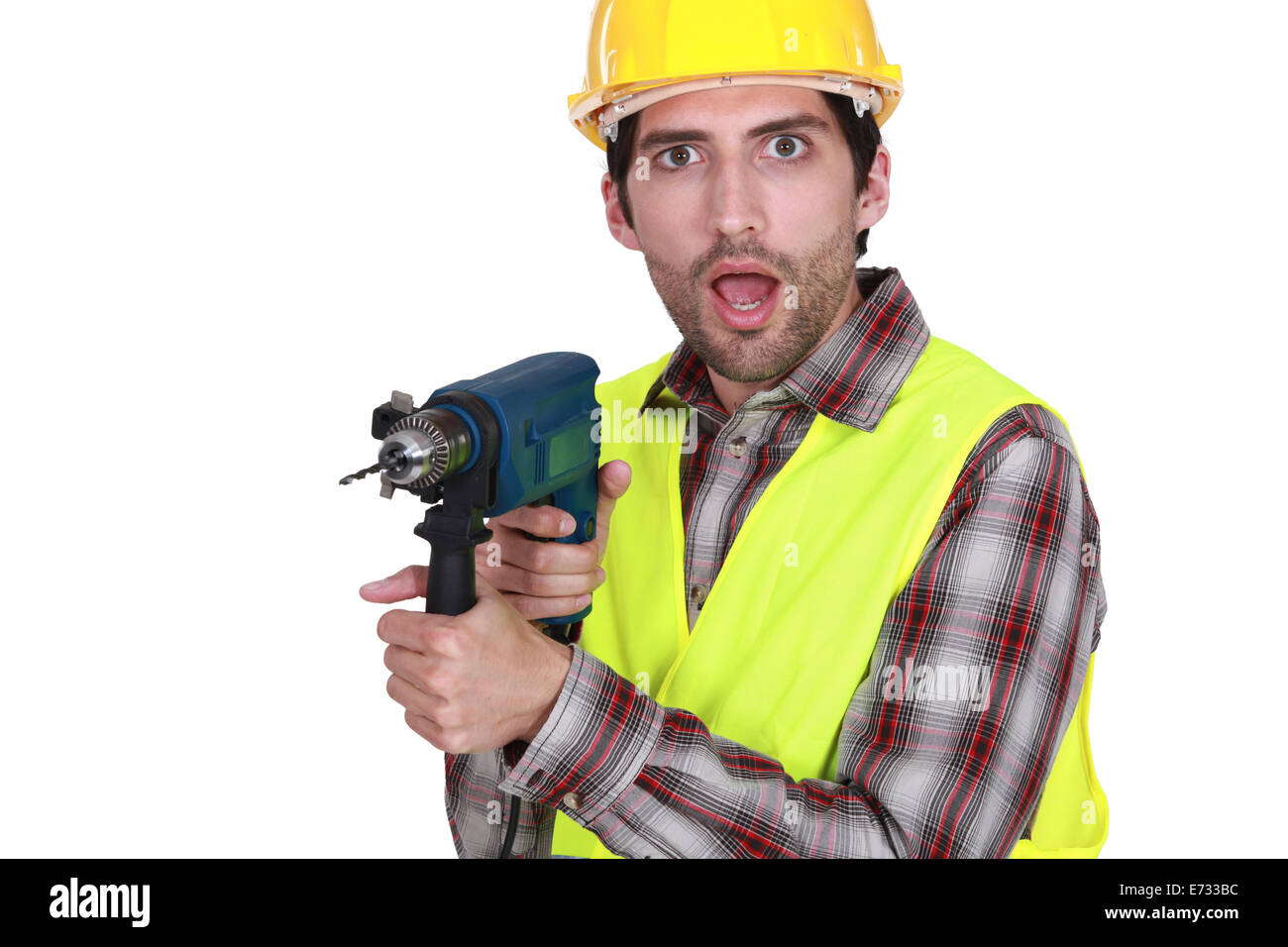 A man holding a drill with a weird facial expression. Stock Photo