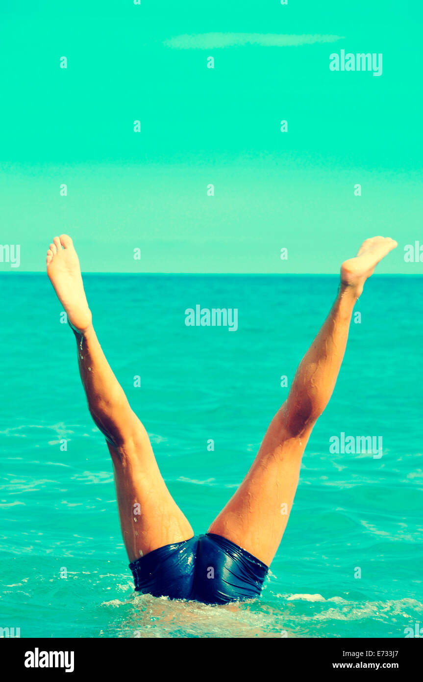 a young man doing a handstand in the sea Stock Photo