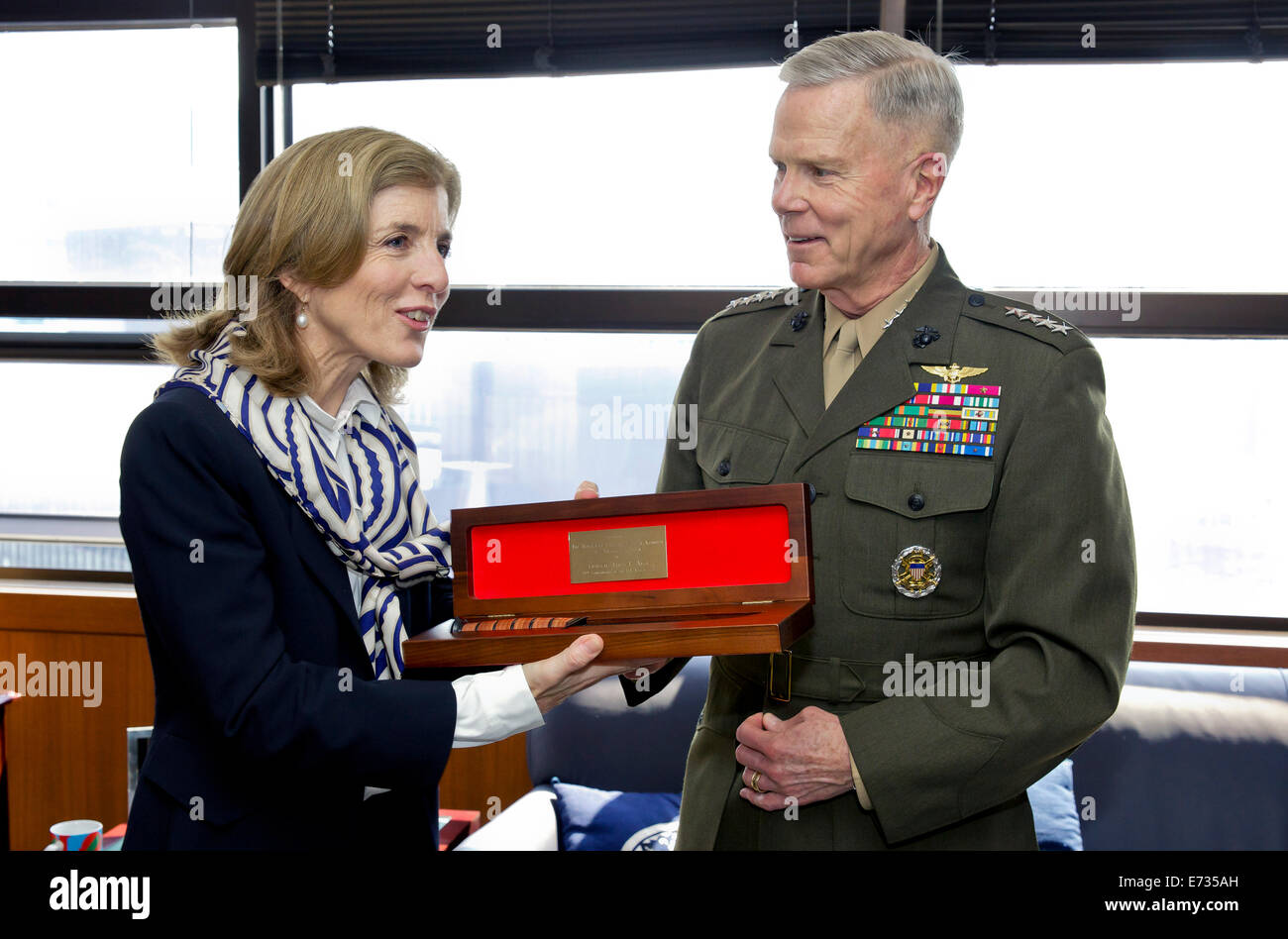 Commandant of the U.S. Marine Corps Gen. James F. Amos presents a gift to U.S. Ambassador to Japan Caroline Kennedy during a visit to the U.S. Embassy April 15, 2014 in Tokyo. Stock Photo
