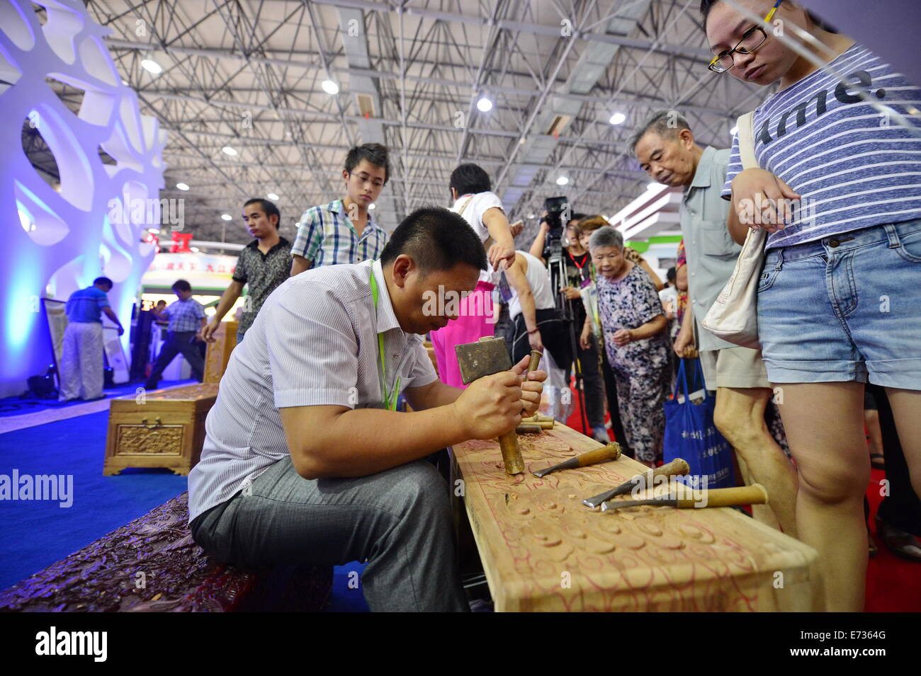 Nanchang, China's Jiangxi Province. 5th Sep, 2014. Visitors watch Yujiang woodcarving during the Jiangxi Tourism Product Fair in Nanchang, capital of east China's Jiangxi Province, Sept. 5, 2014. The three-day fair, which kicked off on Friday, presented more than 3,000 items of Chinese tourism commodities, including 38 intangible cultural heritage items in Jiangxi. © Zhou Mi/Xinhua/Alamy Live News Stock Photo