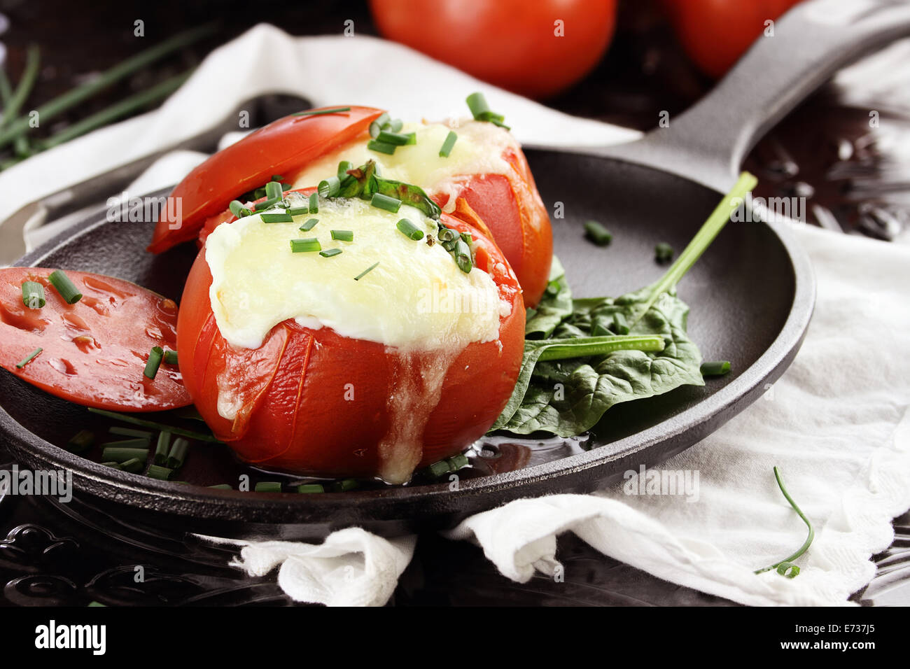 Eggs with mozzarella cheese baked in fresh tomatoes Stock Photo