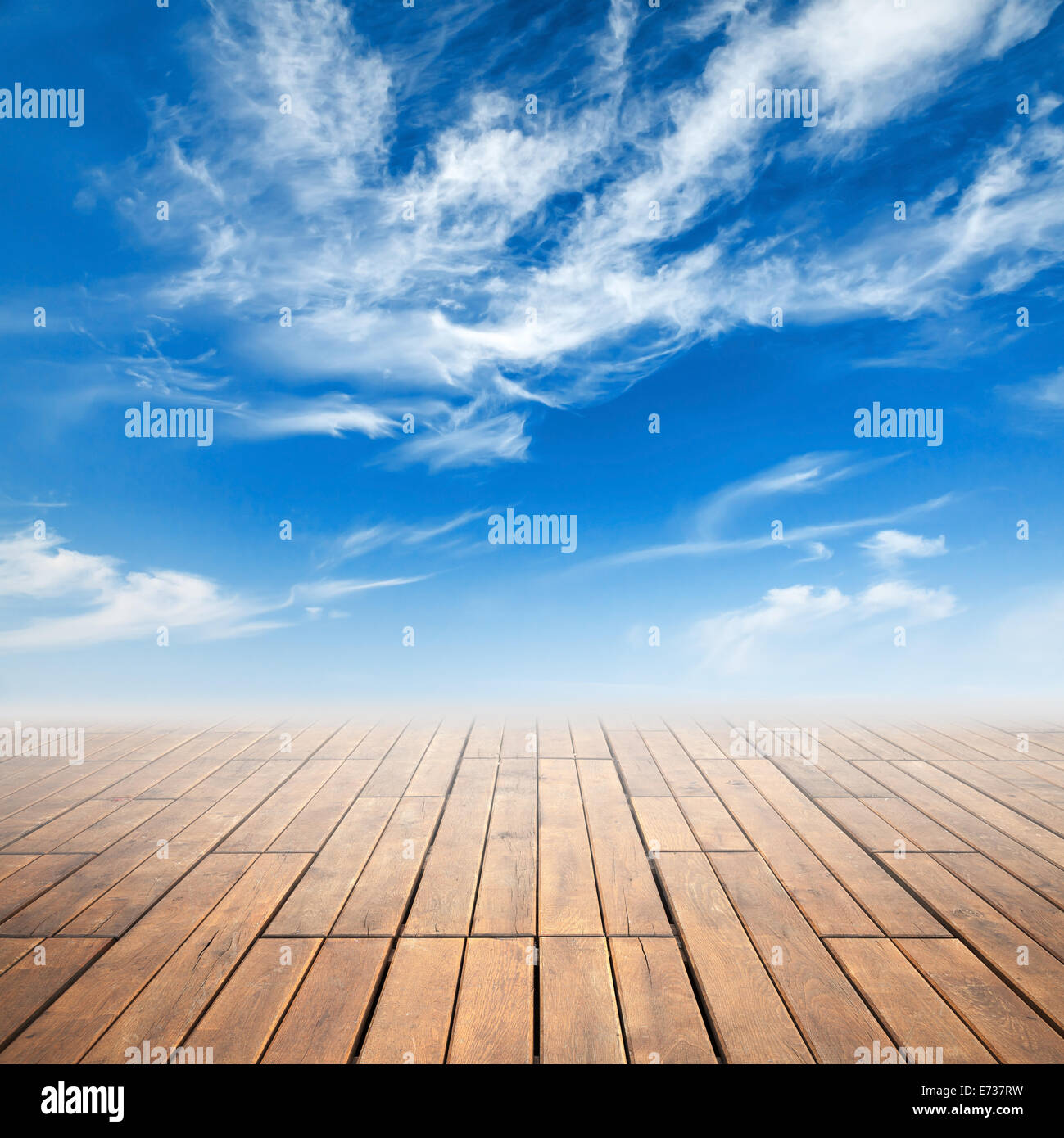 Brown wooden floor with perspective and bright cloudy sky Stock Photo
