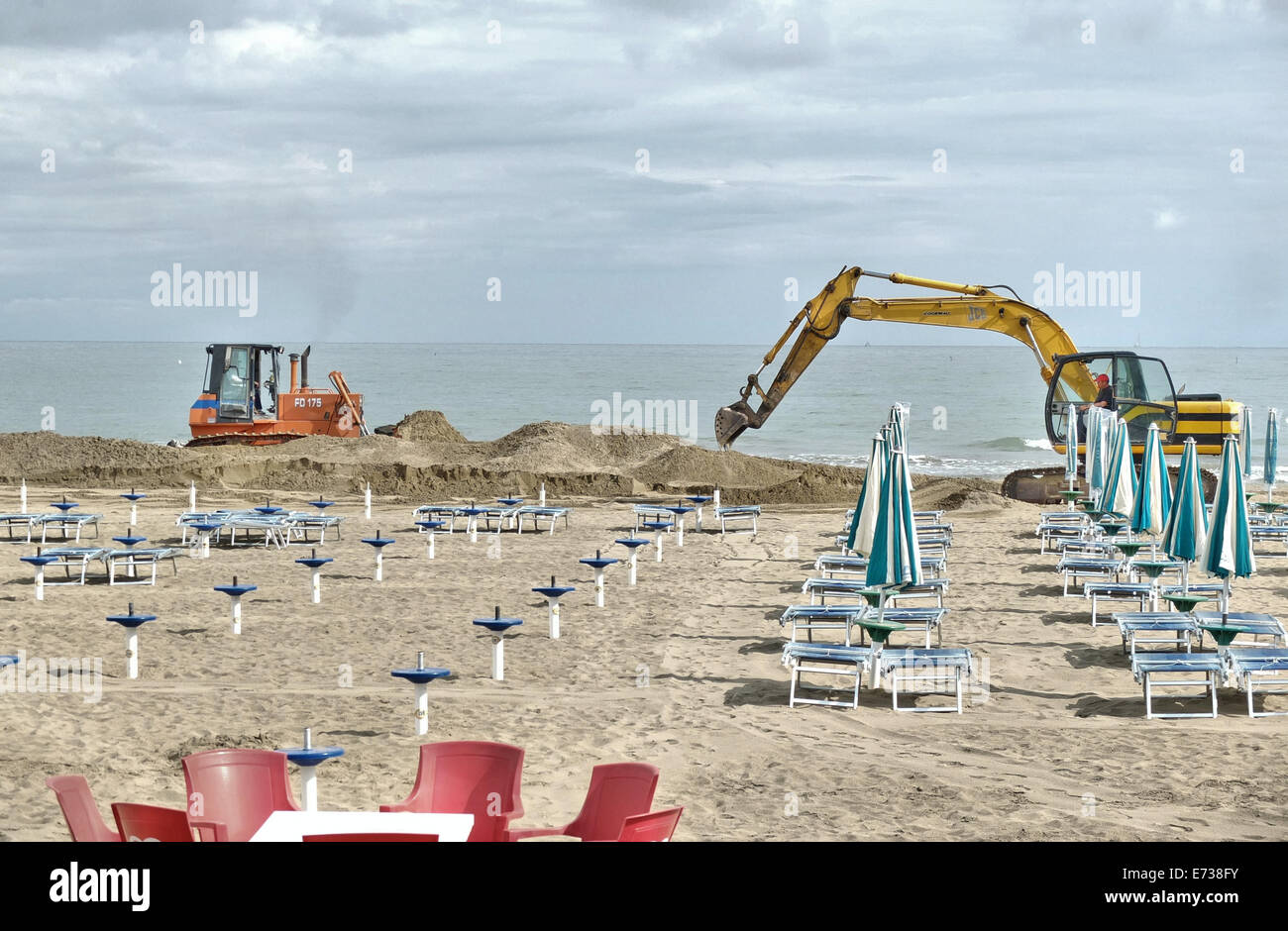 Caorle, Veneto, Italy . May 2014,  Early spring seazon at the Adriatic Sea beach in Caorle resort. Worker cleaning beach amoung  Stock Photo