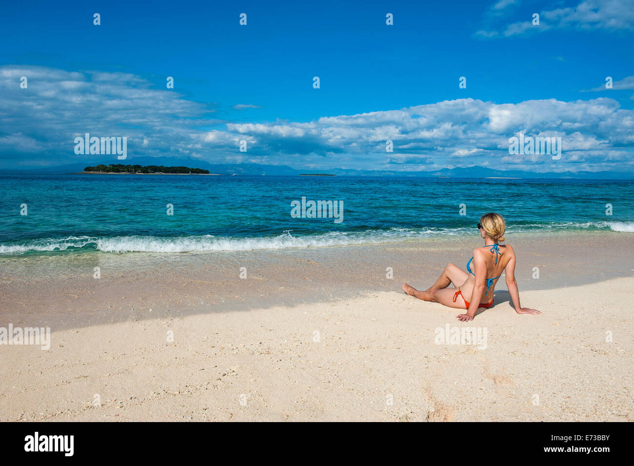 Woman sitting on a the white sand beach of Beachcomber Island, Mamanucas Islands, Fiji, South Pacific, Pacific Stock Photo