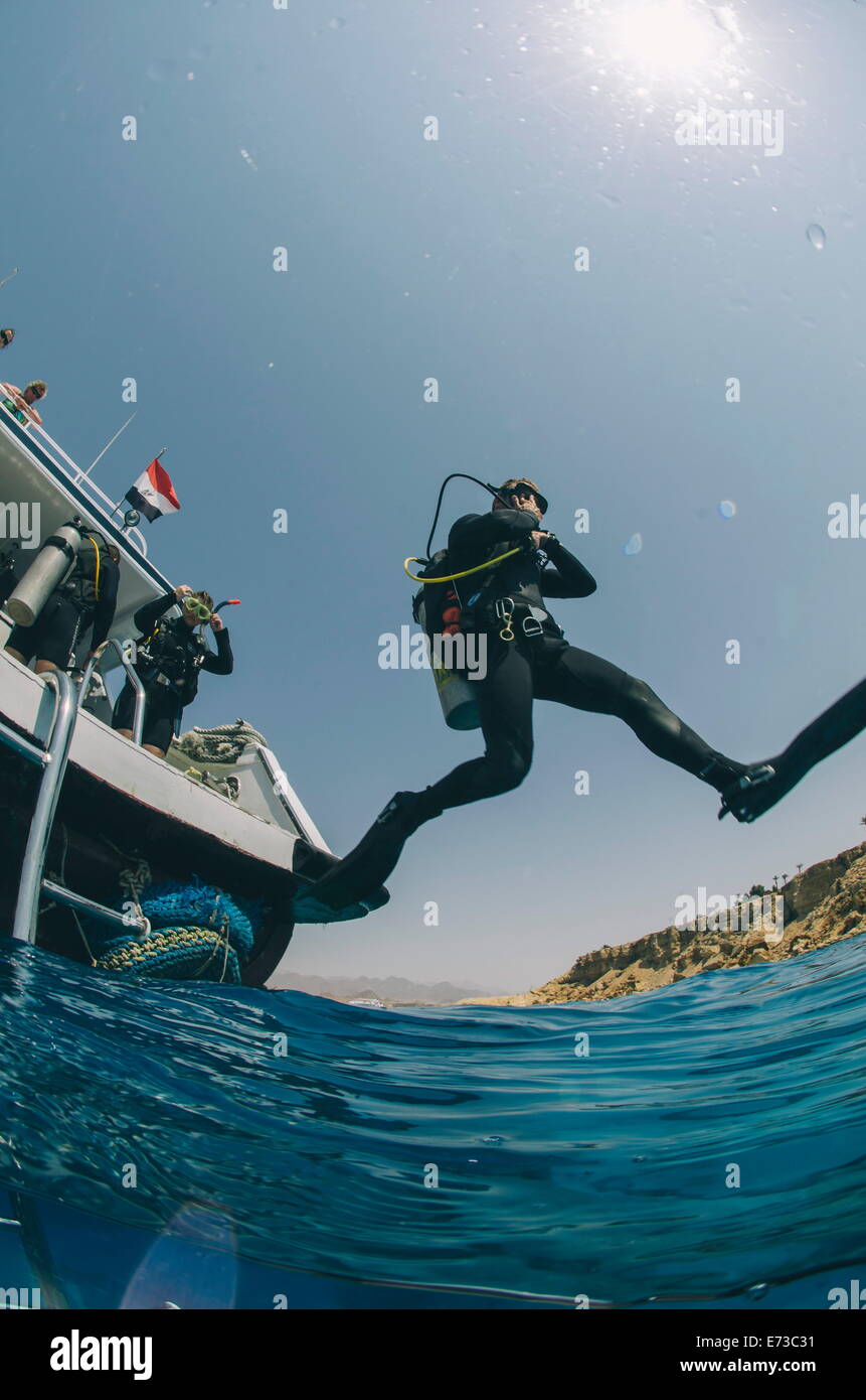 Scuba diver making giant stride entry into the water, Red Sea, Egypt, North Africa, Africa Stock Photo
