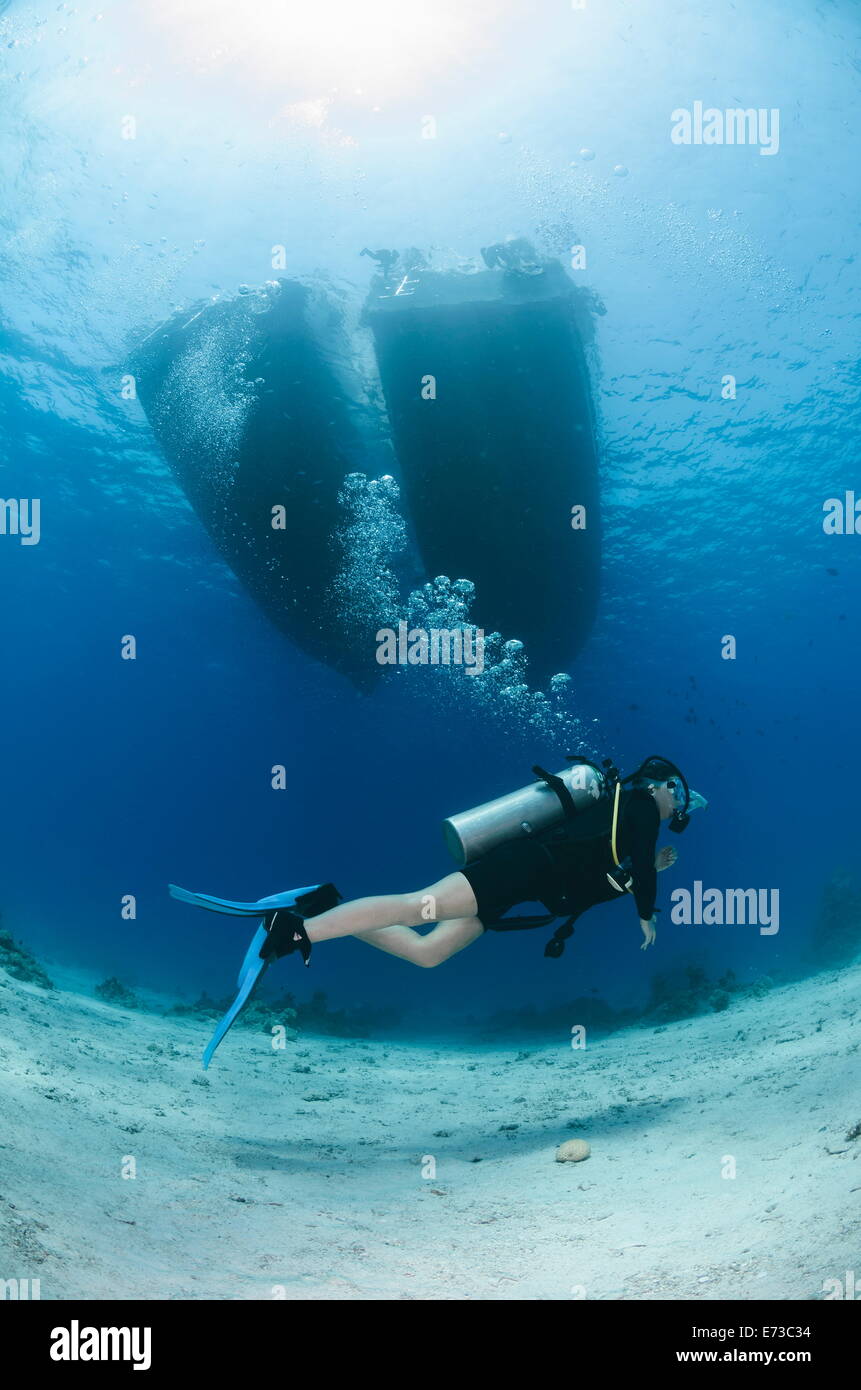 Female scuba diver swimming underneath moored up dive boats, Sharm El Sheikh, Red Sea, Egypt, North Africa, Africa Stock Photo