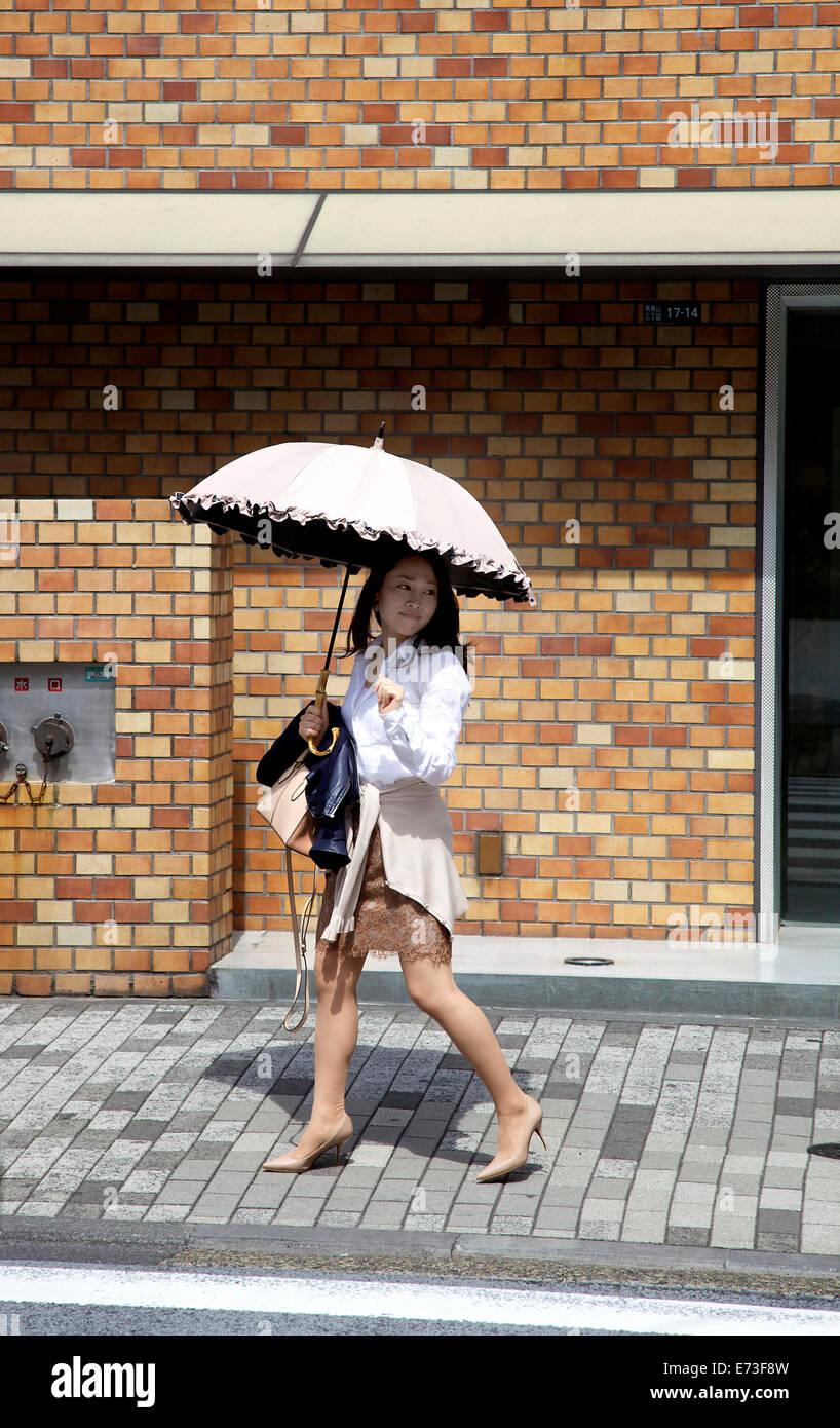 Girl, young woman walking with umbrella for sun protection. Omote-sando, Harajuku area, Tokyo, Japan, Asia Stock Photo