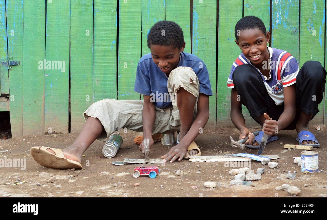 Madagascar, Antananarivo, boys making small car toys out of cans and other recycled material. Stock Photo