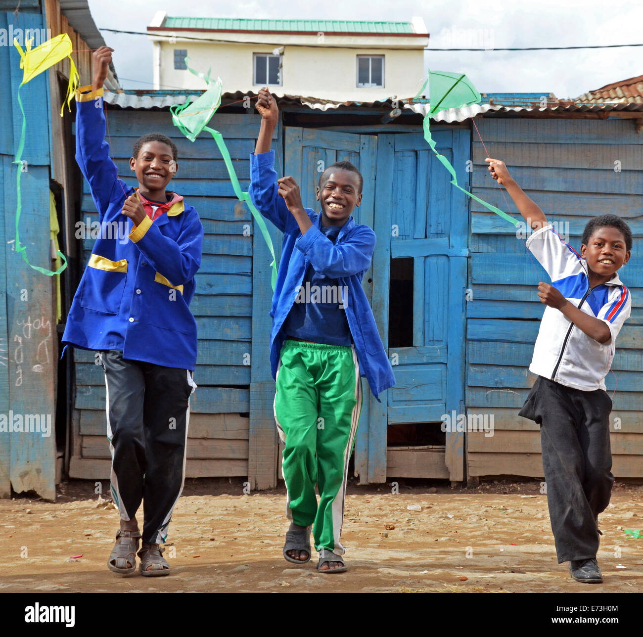 Madagascar, Antananarivo, 3 boys flying a kit in the courtyard of school. Stock Photo