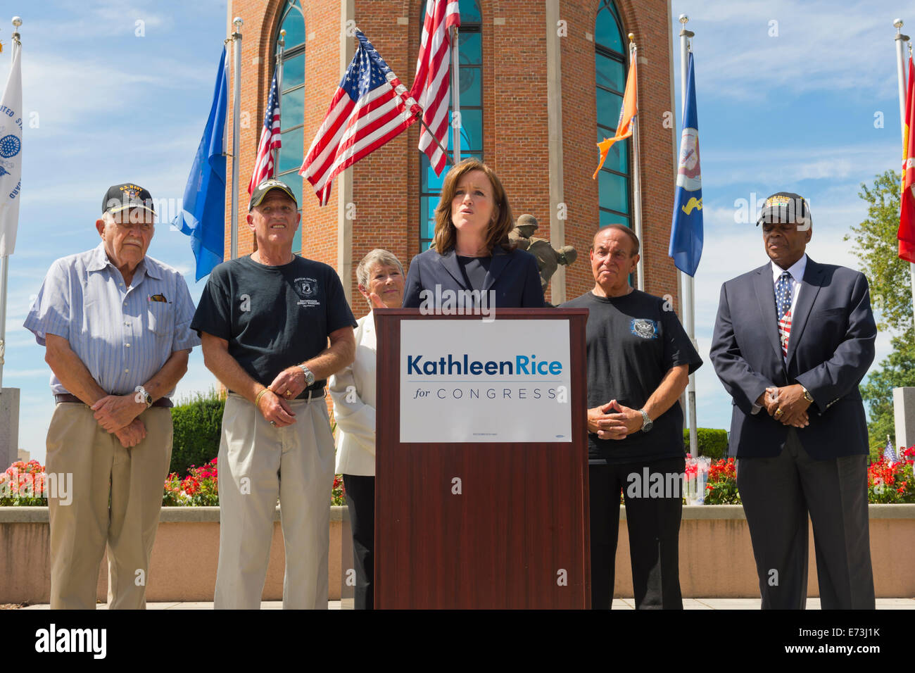 East Meadow, New York, USA. 3rd September, 2014.  KATHLEEN RICE, at podium, Democratic congressional candidate (NY-04), releases a whitepaper on veterans policy and announces formation of her campaign's Veterans Advisory Committee, at Veterans Memorial at Eisenhower Park, after touring Northport VA Medical Center with outgoing Rep. CAROLYN MCCARTHY (in white jacket). Congresswoman McCarthy and 4 committee members joined Rice at the press conference: PAUL ZYDOR, (in blue shirt) of Merrick, U.S. Navy, Korean War Veteran; PAT YNGSTROM, (in black T-shirt and cap) of Merrick, U.S. © Ann E Parry/Ala Stock Photo
