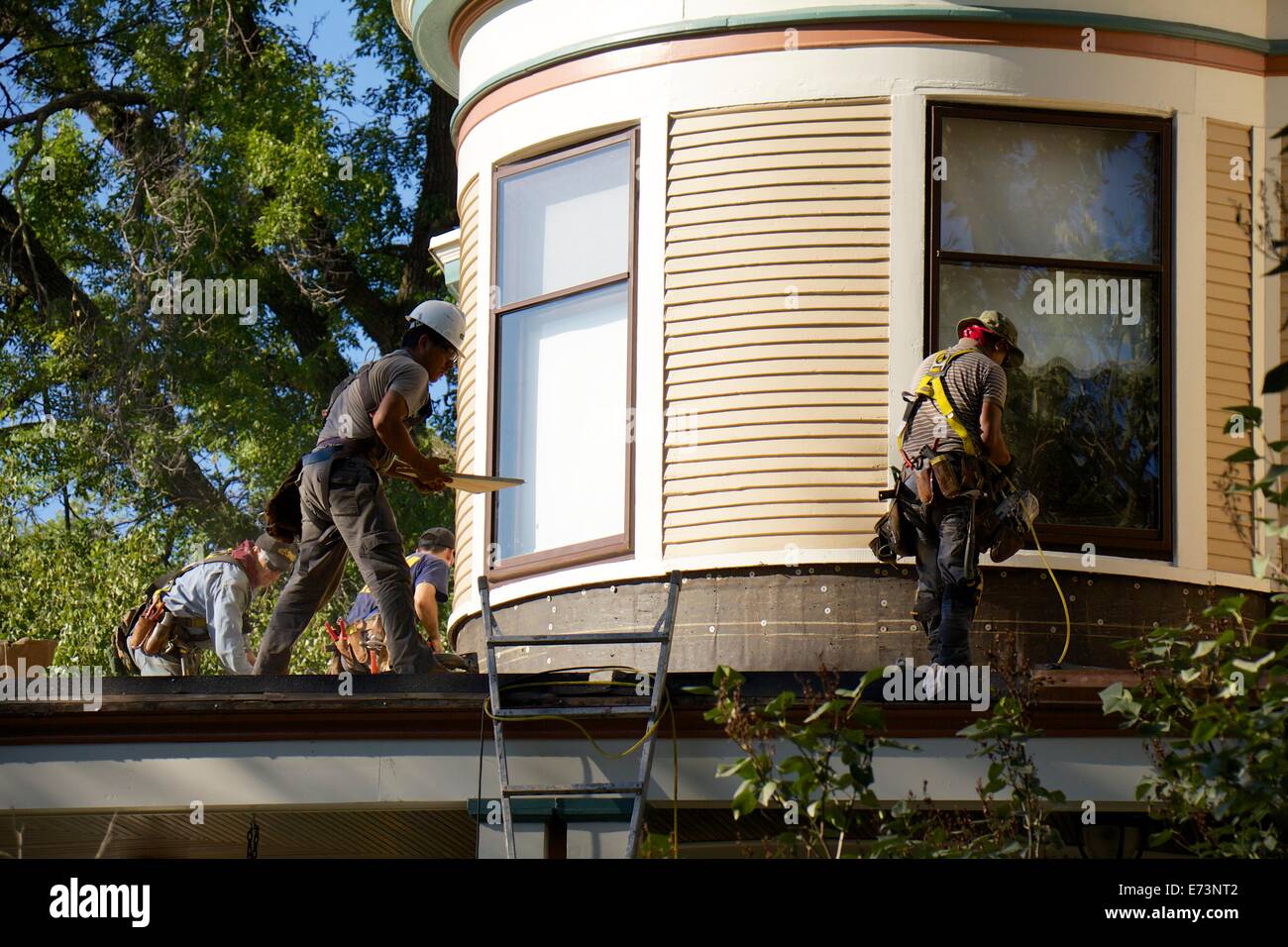 Workmen restoring exterior of house. Stock Photo
