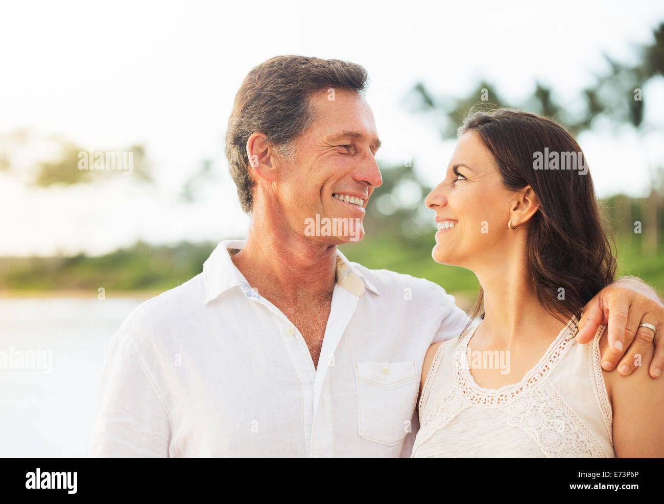 Mature Retired Couple Enjoying Tropical Sunset Beach Vacation Stock Photo