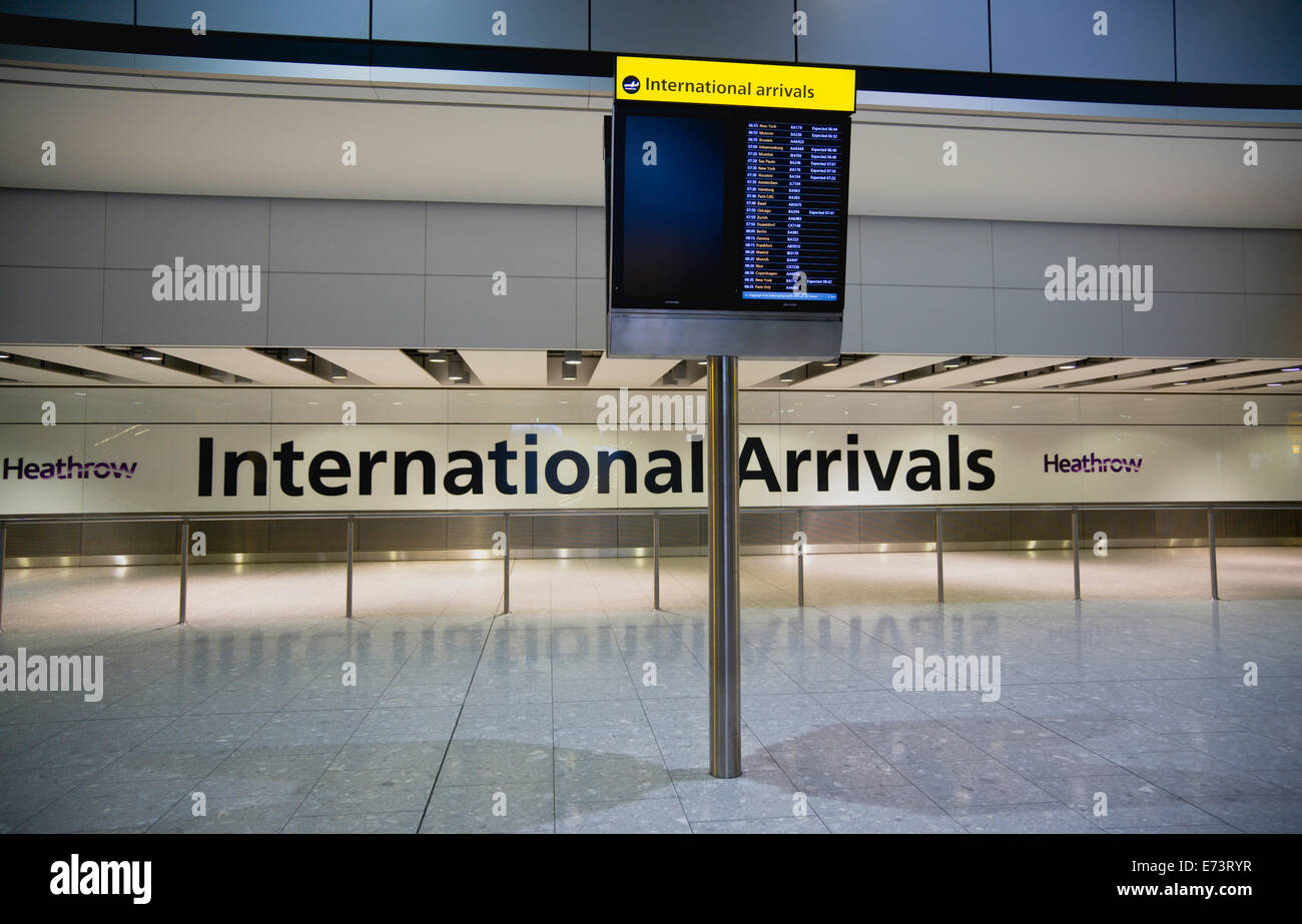 England, London, Heathrow Airport, deserted International Arrivals hall with electronic arrivals board listing incoming flights. Stock Photo