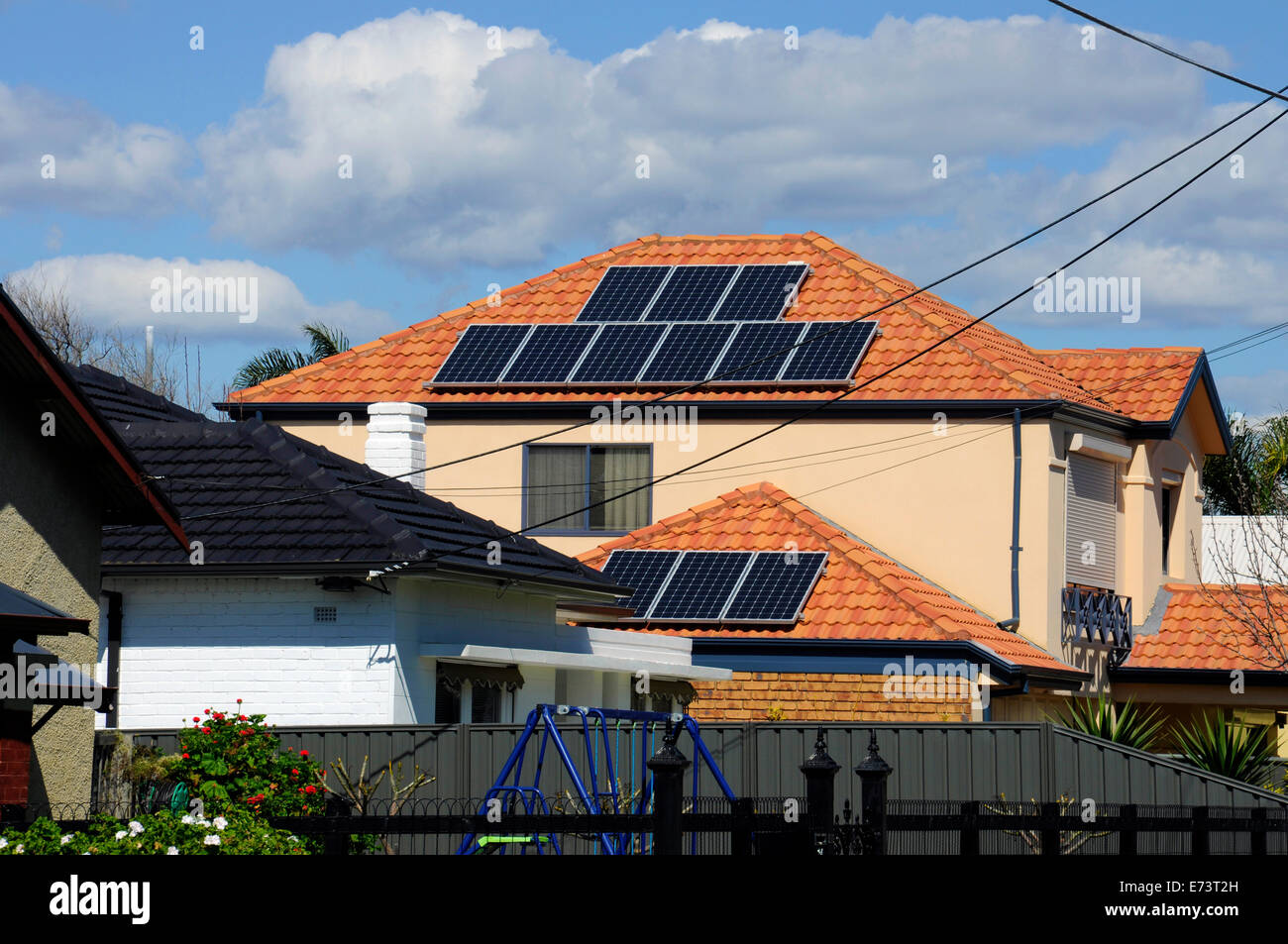 Australian photovoltaic solar power panels on suburban house roof top. Stock Photo