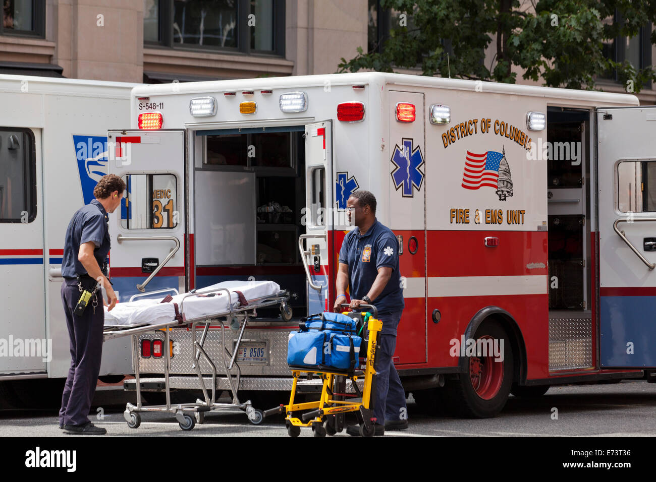 EMTs loading stretcher on EMS ambulance - Washington, DC USA Stock Photo