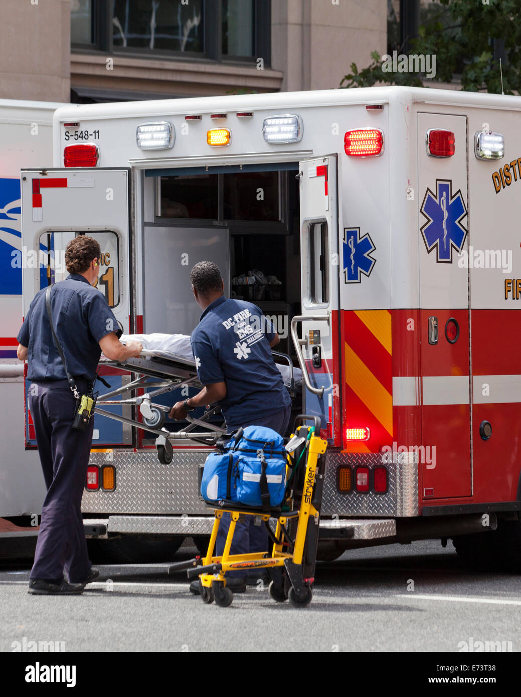 EMTs loading stretcher on EMS ambulance - Washington, DC USA Stock Photo