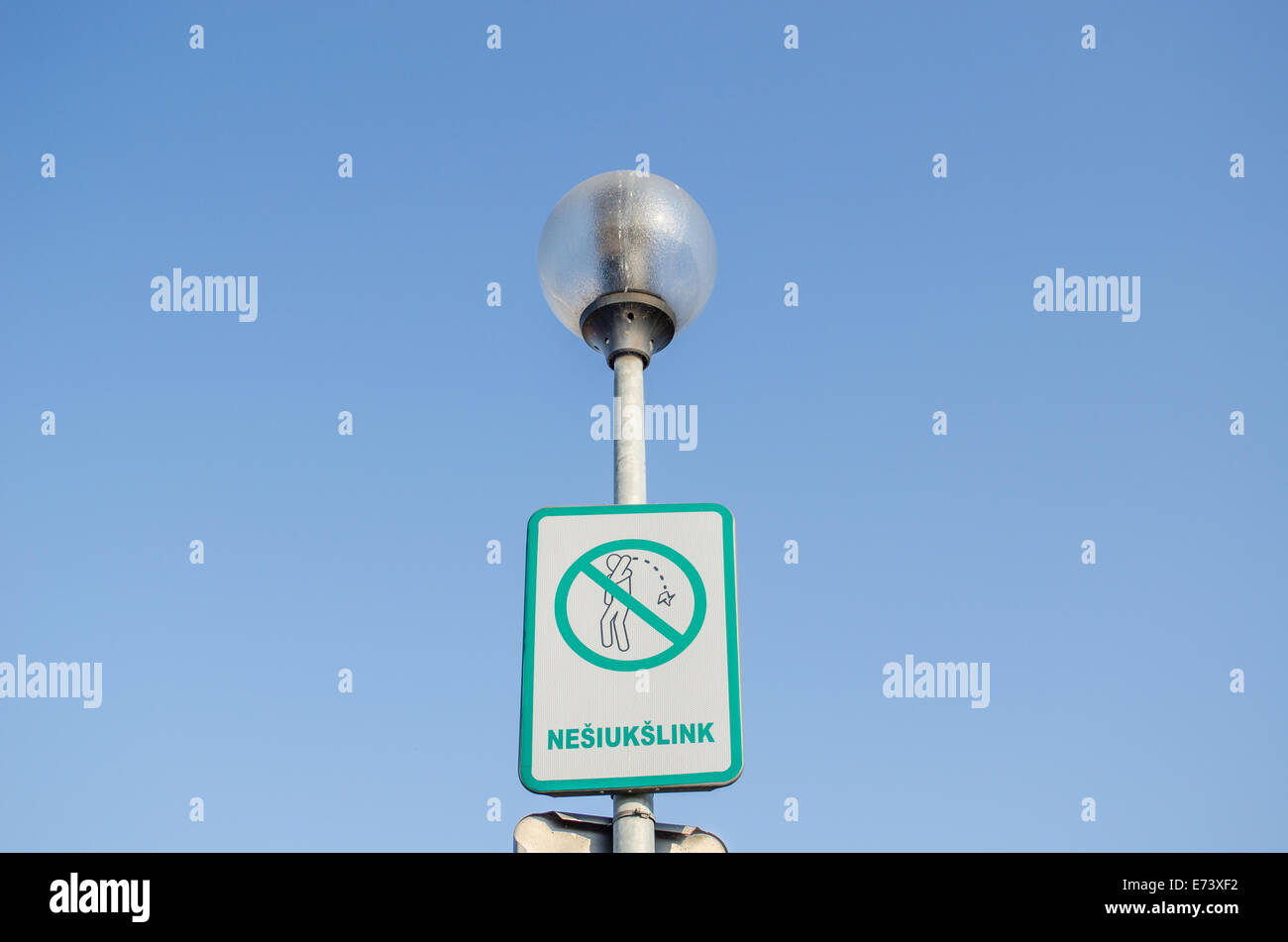 warning information street sign the ban on littering the streets with lithuanian inscription on the street lamp Stock Photo