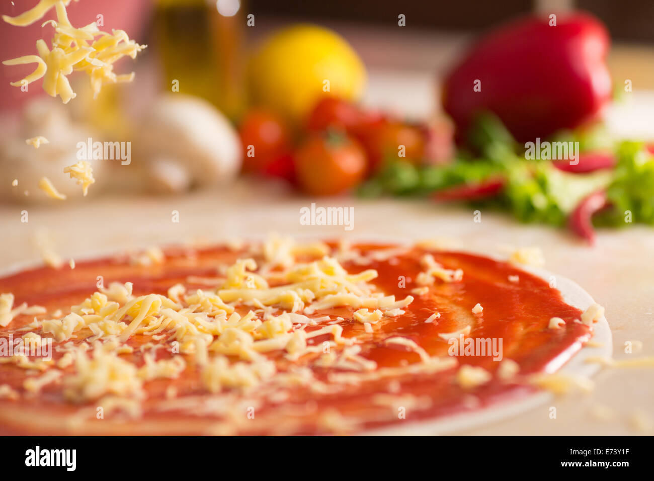Italian pizza preparation with cheese falling. Stock Photo