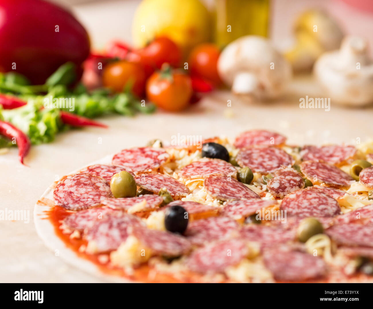 raw salami italian pizza with capers Stock Photo