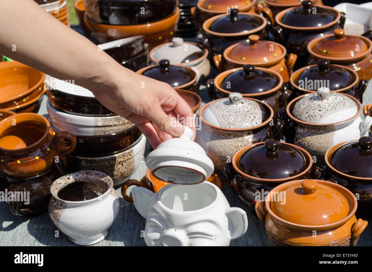 stall full of clay handmade pots and woman hand hold clay lit Stock Photo