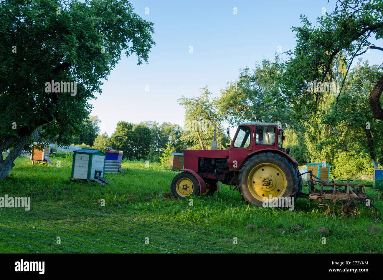 rural farm tractors in the summer garden to the hive Stock Photo