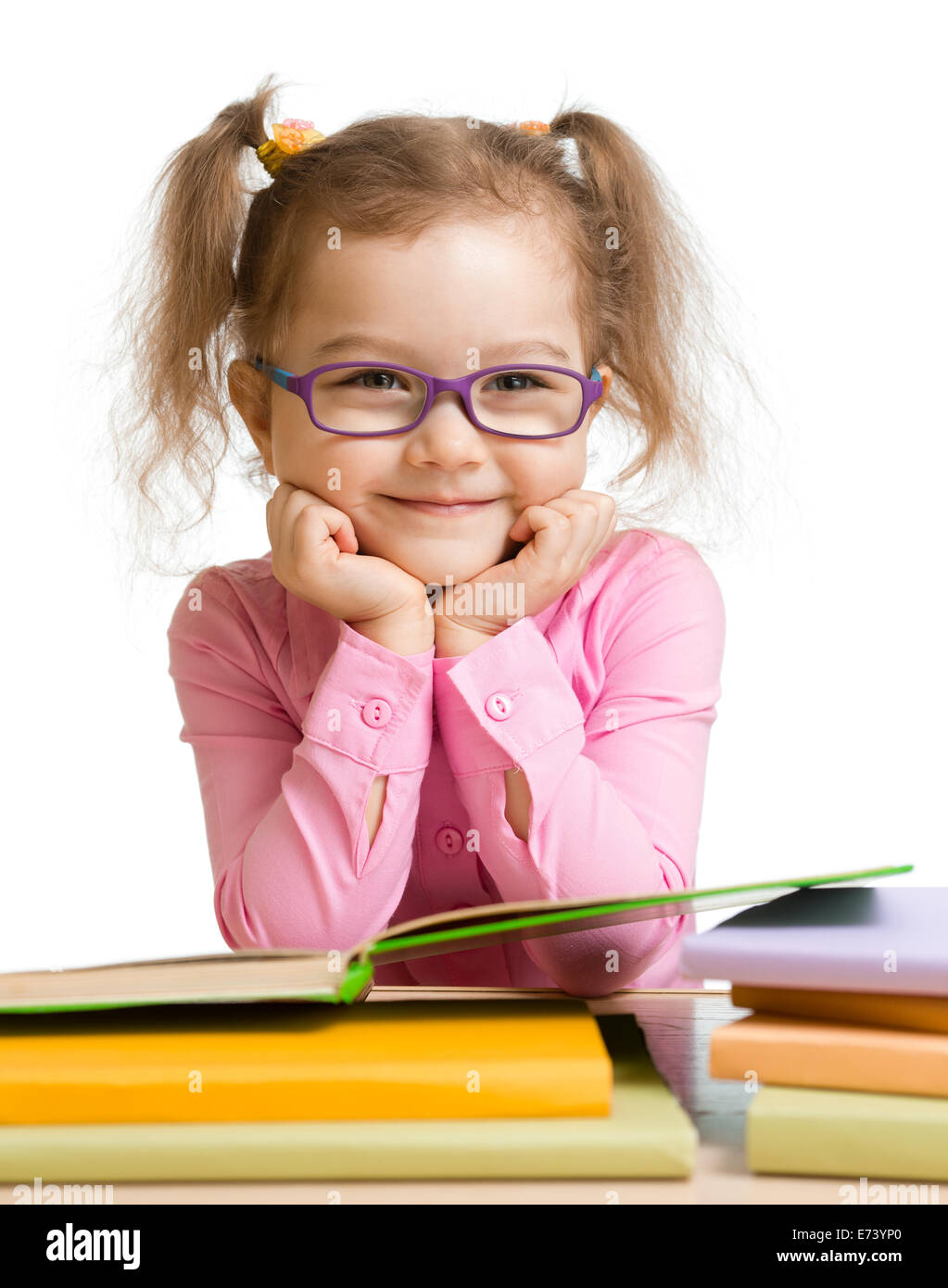 child girl in glasses reading book and smiling Stock Photo