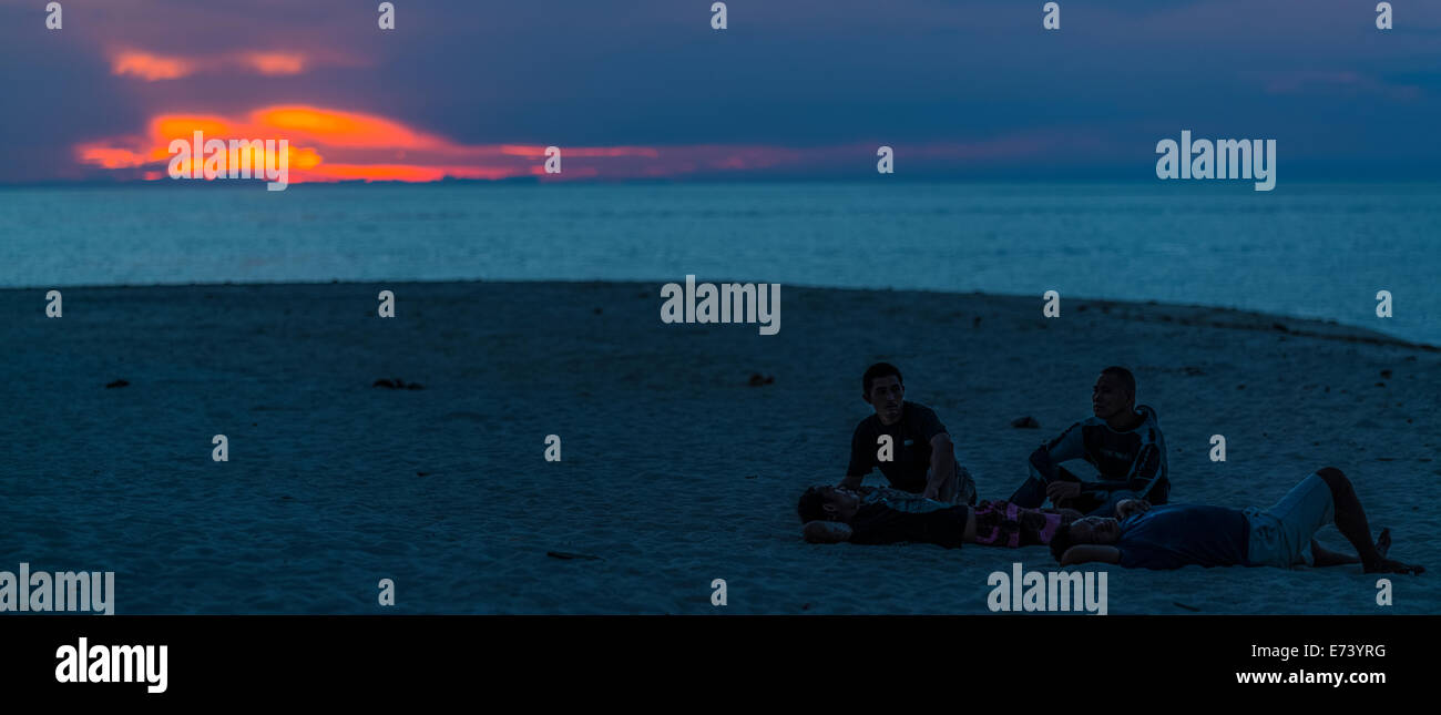 Fishermen enjoying the sunset on White Island, Camiguin, Philippines Stock Photo