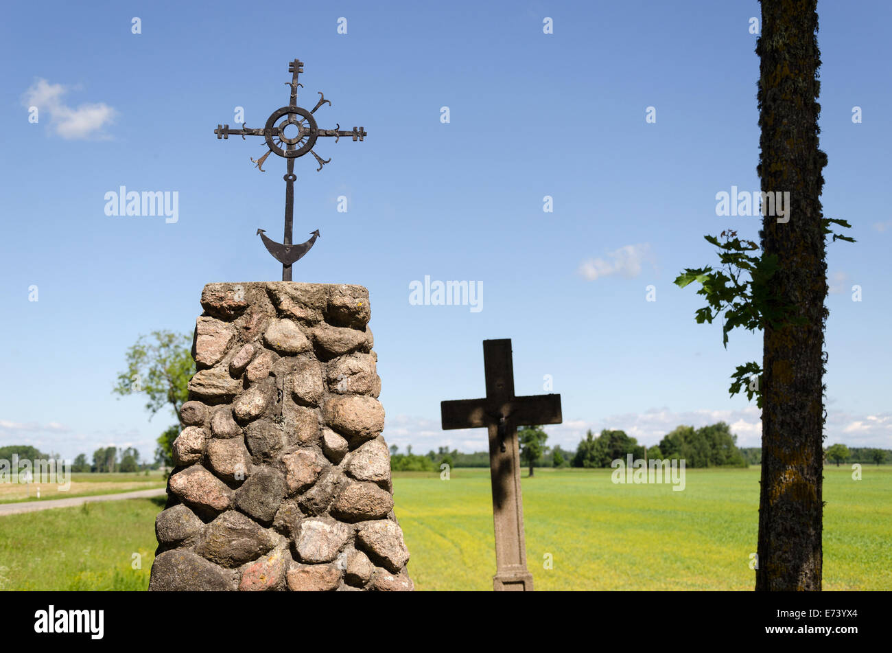 stone monument with metal ornament squirm cross in summer nature Stock Photo