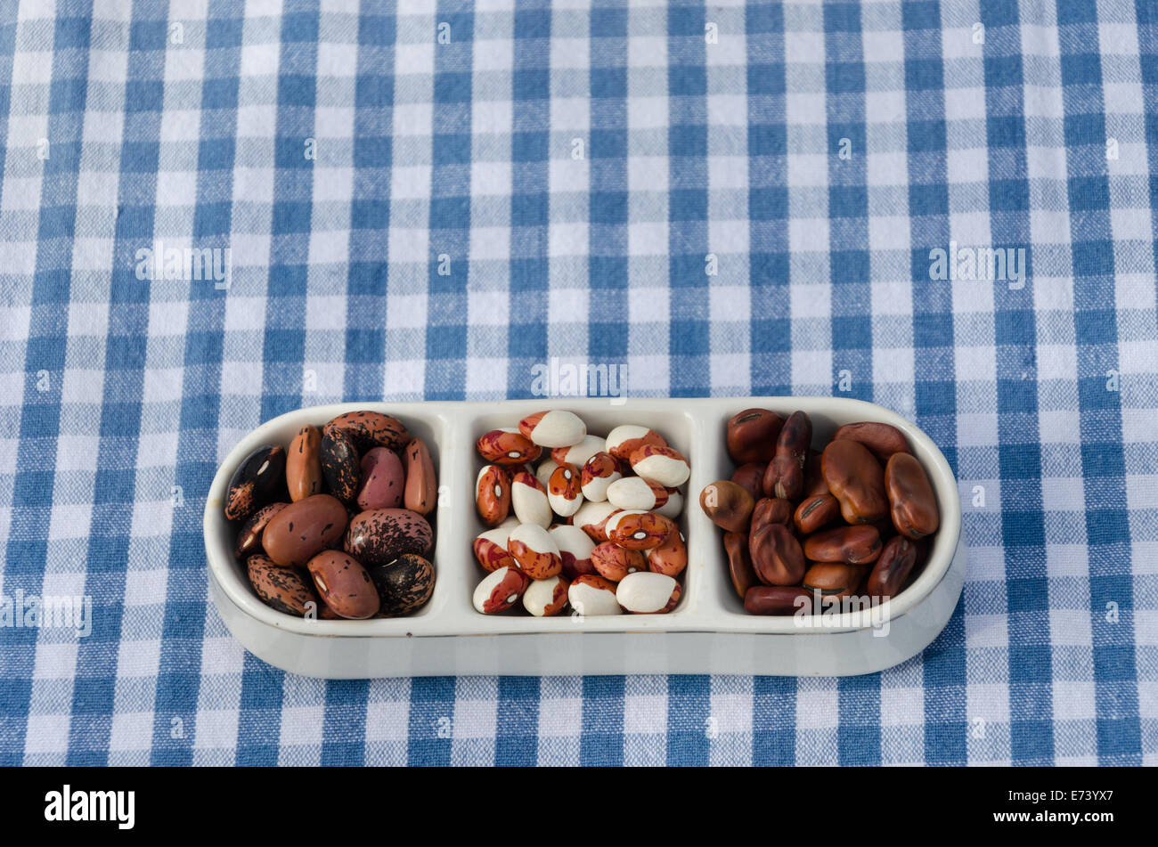 close up of beans mix on three pieces plate on plaid tablecloth background Stock Photo