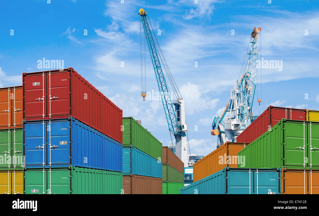 export or import shipping cargo container stacks and port cranes Stock Photo