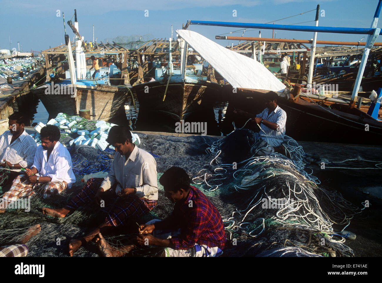 Migrant workers from Kerala mending fishing nets in Qatar 1985 Stock