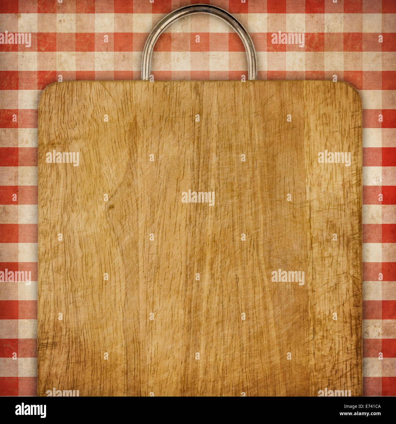 hardboard or breadboard over red checked gingham picnic tablecloth grunge background Stock Photo